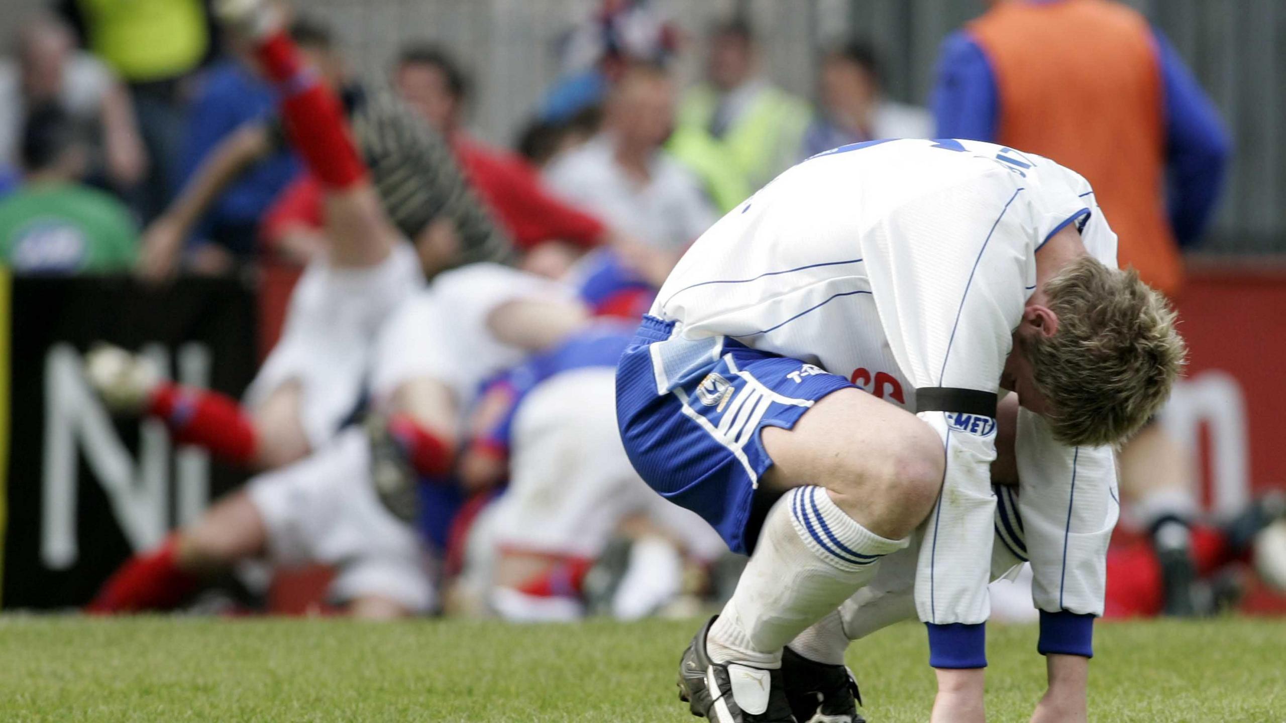 Mark McAllister falls to his knees as Linfield celebrate
