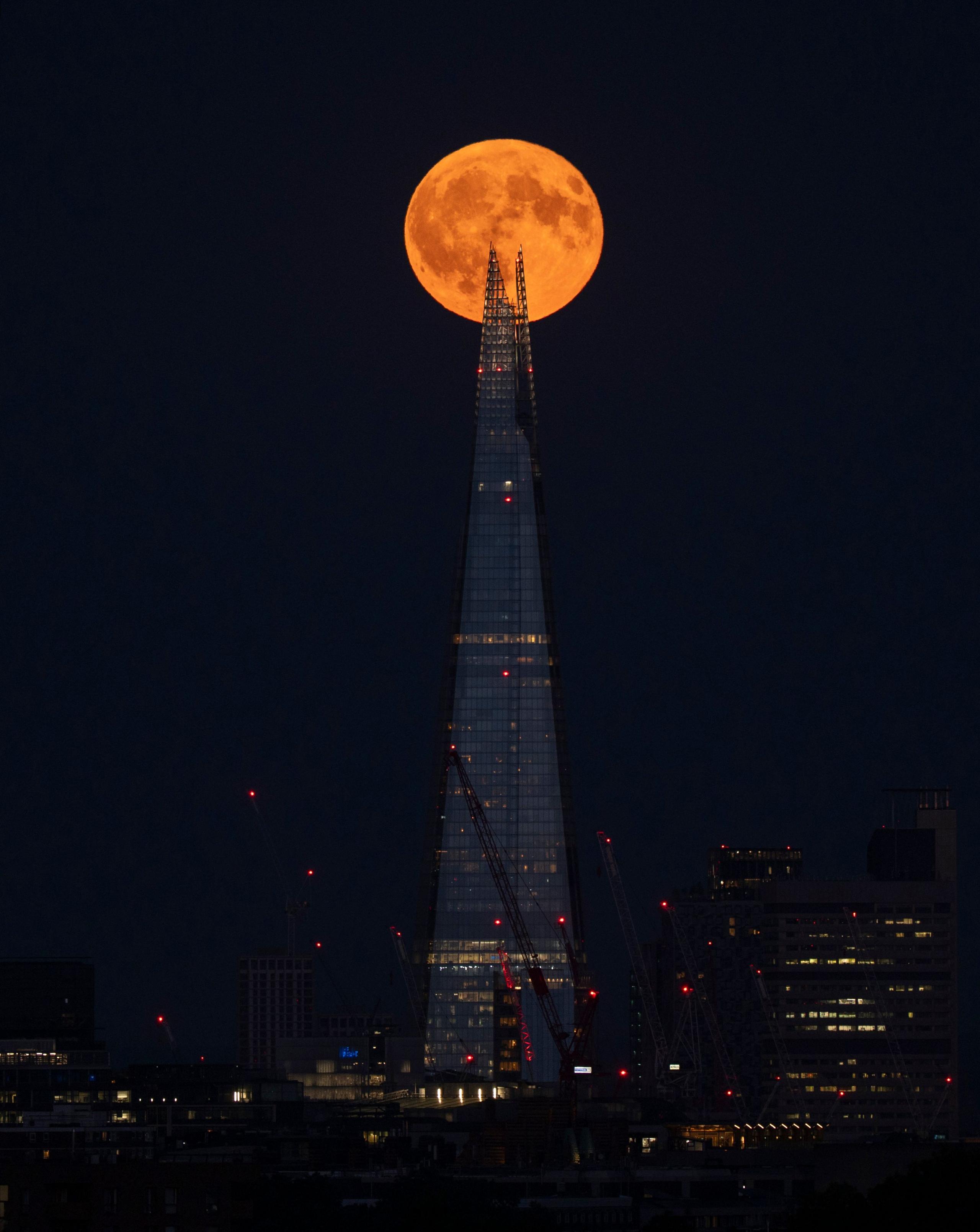 The Full Buck supermoon rises over The Shard in central London.