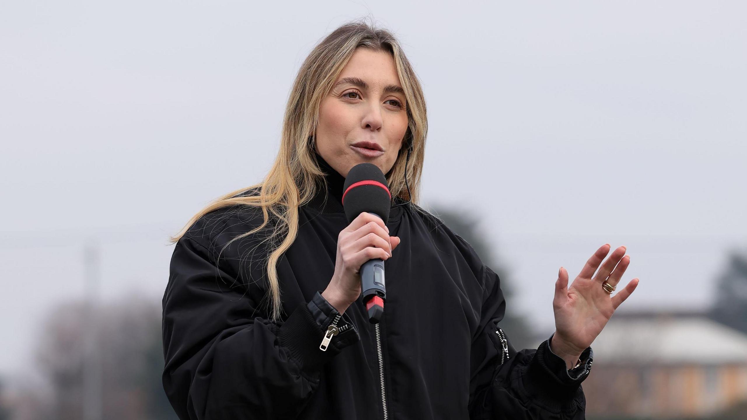 Victoire Cogevina Reynal speaking into a microphone before a Como FC match