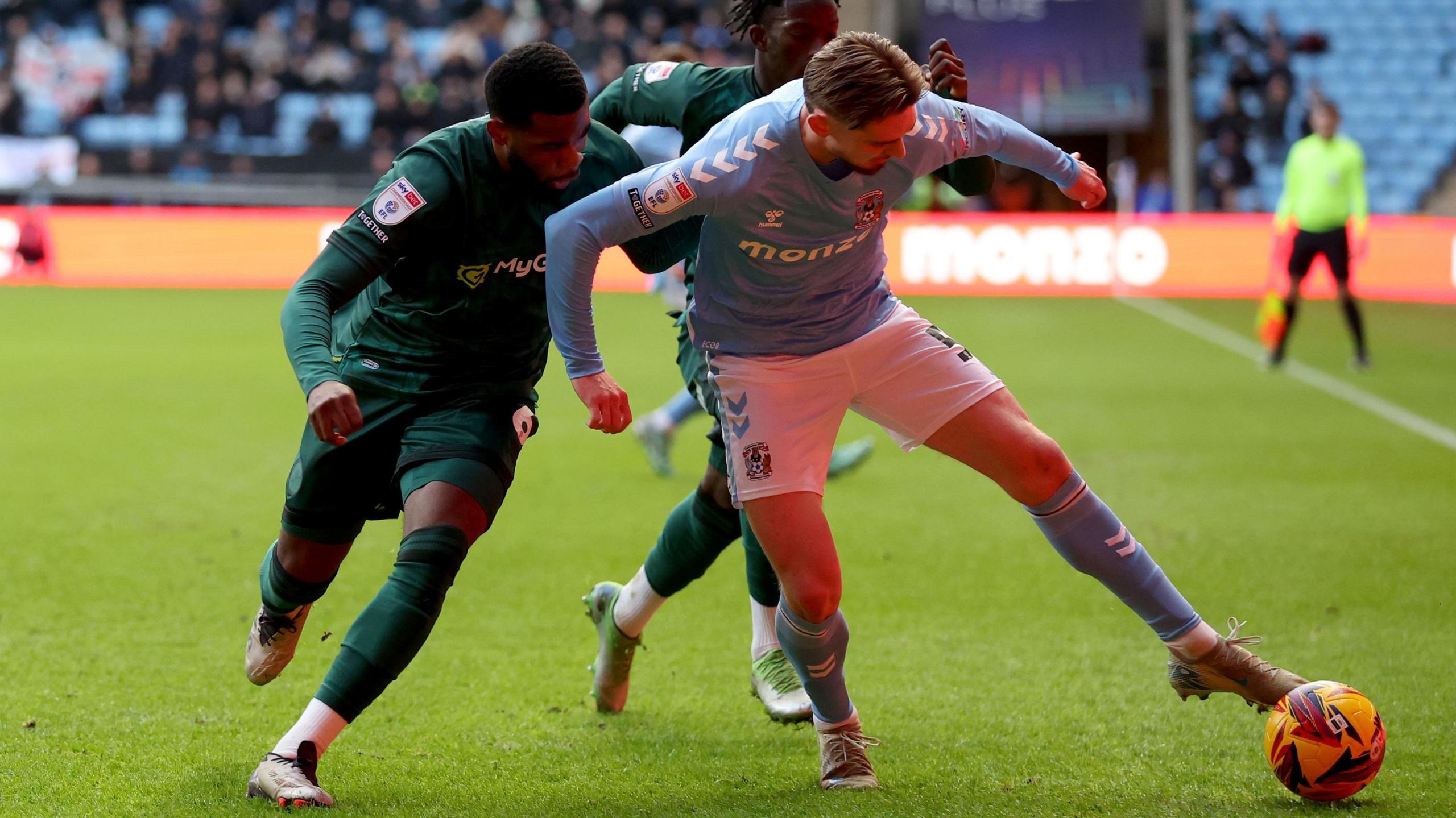 Millwall's Japhet Tanganga (left) and Coventry City's Jack Rudoni tangle at the Coventry Building Society Arena