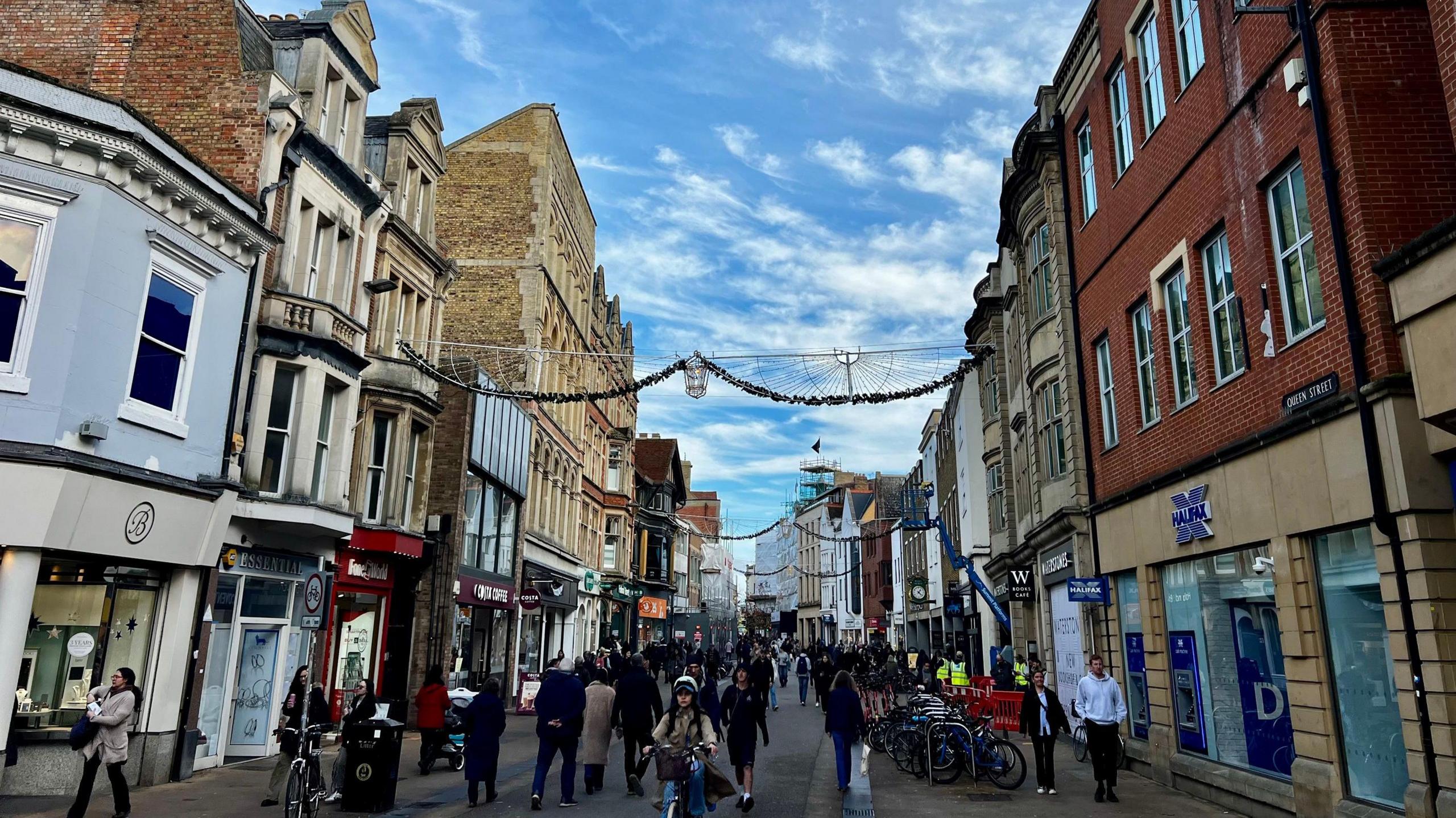 A general view picture of Queen Street in Oxford, with shops and other units on both sides.