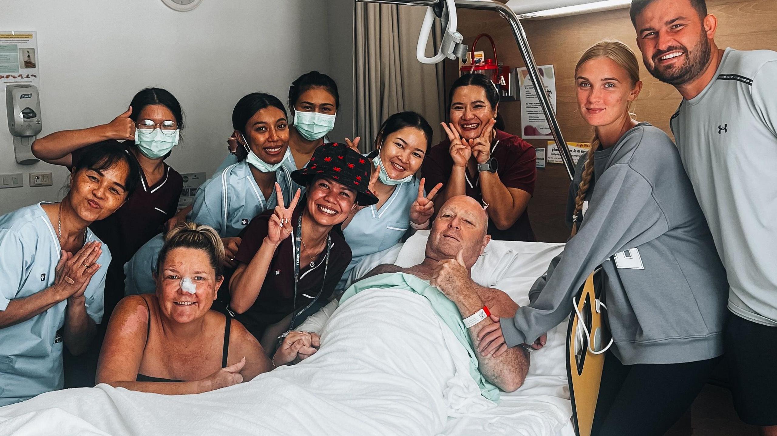 Lee Francis surrounded by family and nurses in hospital in Thailand