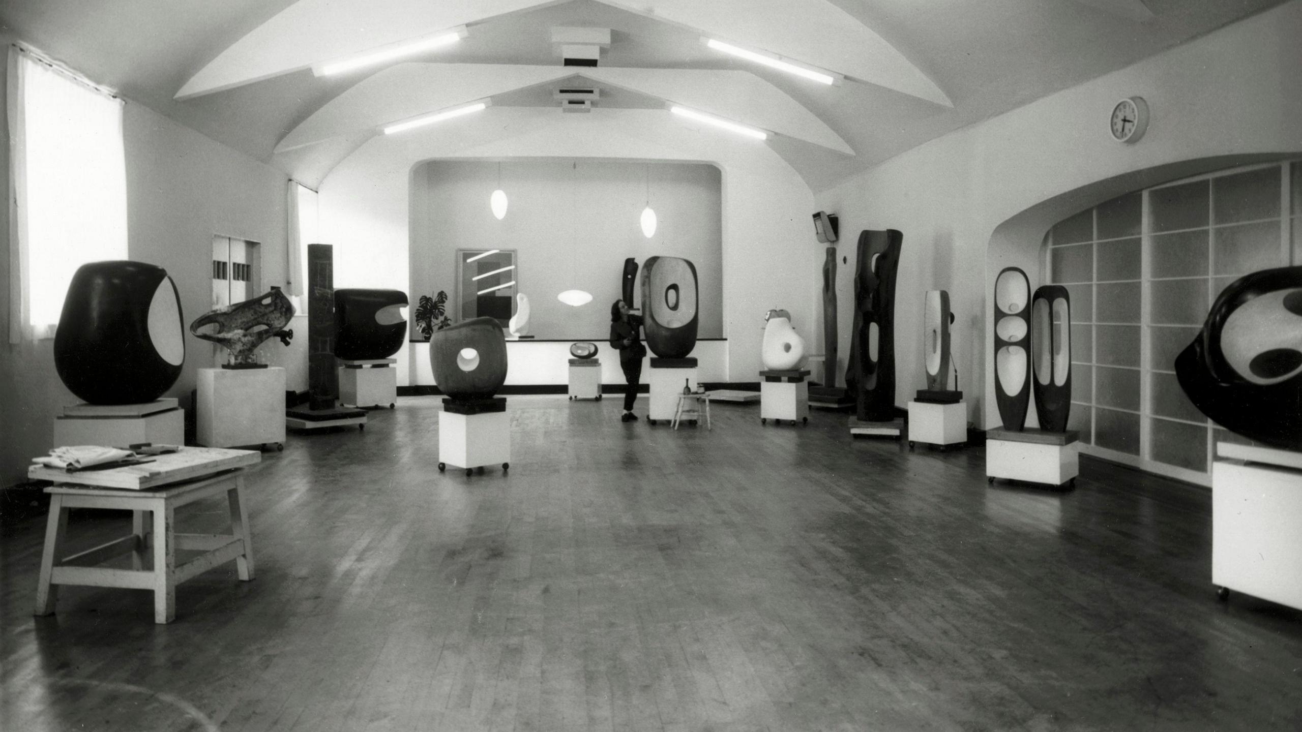 A black and white photograph showing Barbara Hepworth on the dance floor of the Palais de Danse in March 1961 with sculptures throughout the room