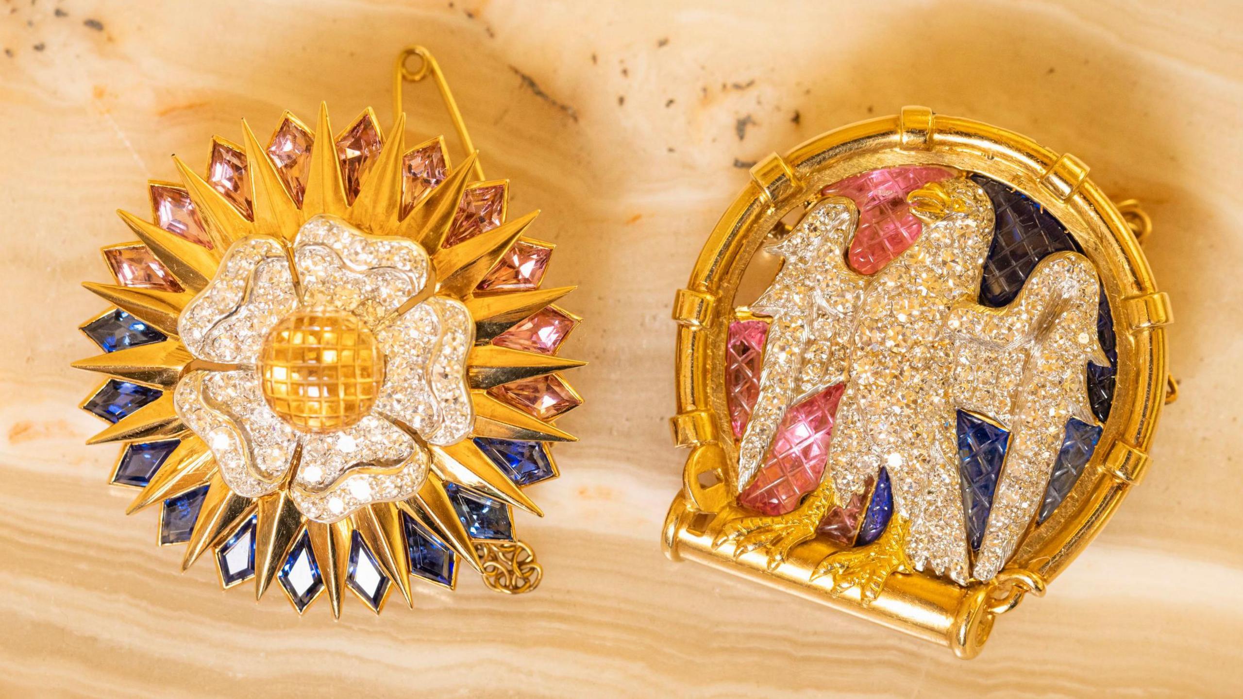 Two diamond-encrusted Cartier brooches depicting a falcon and a white Tudor rose.