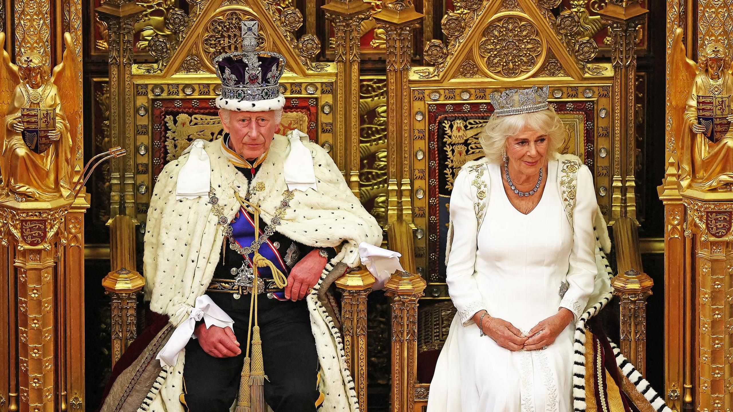 king charles iii and queen camilla sit on thrones in the house of lords