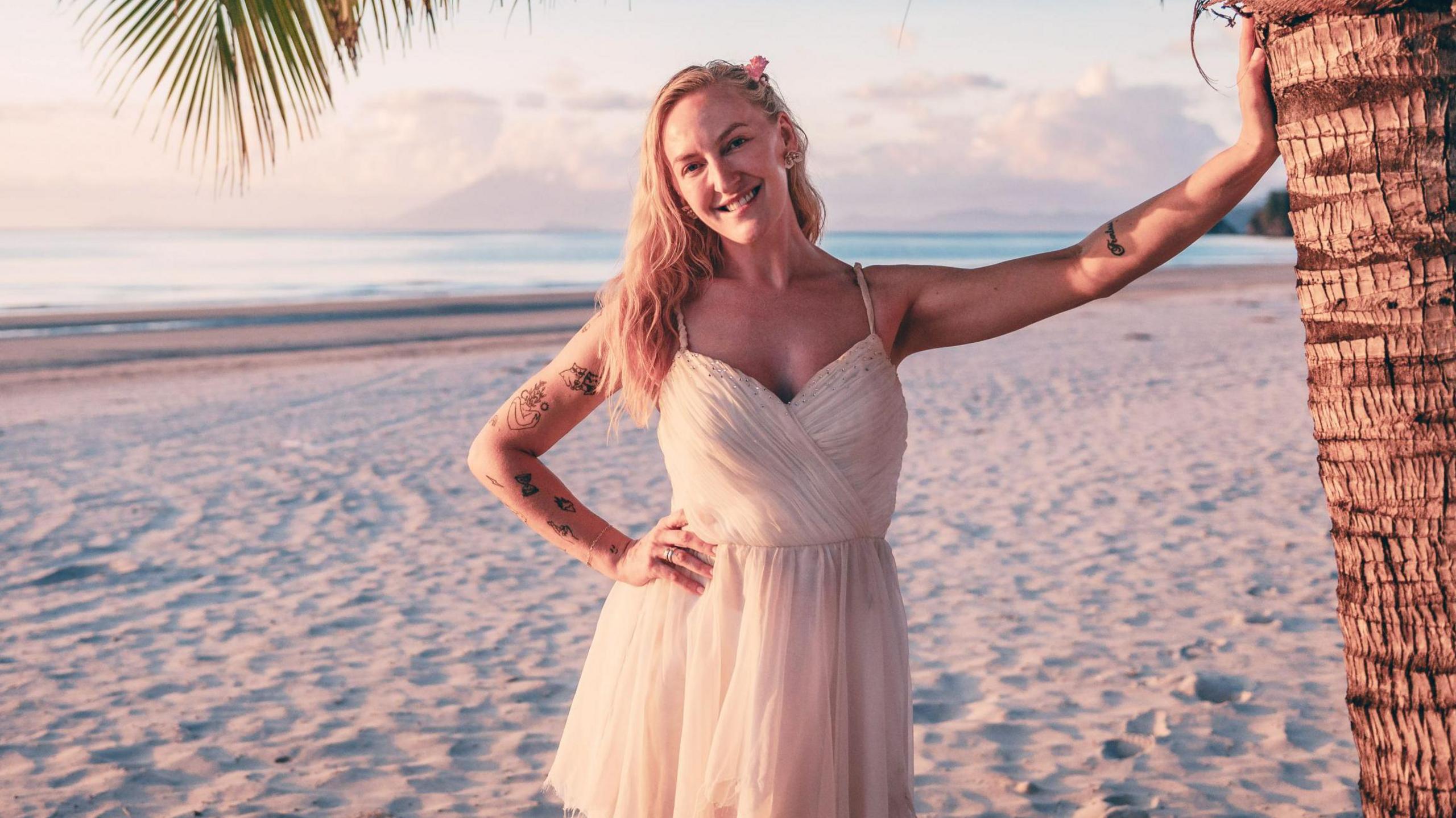 A picture of Helen in a white dress on a beach