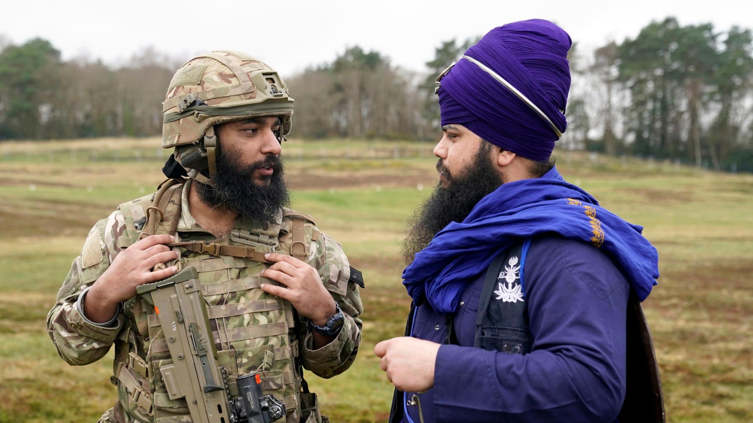 A Sikh soldier of the British Army chats to a member of Bhudda Dal UK as they take part in the Holla Mahalla Sikh military festival, at the Aldershot Garrison, Hampshire. 