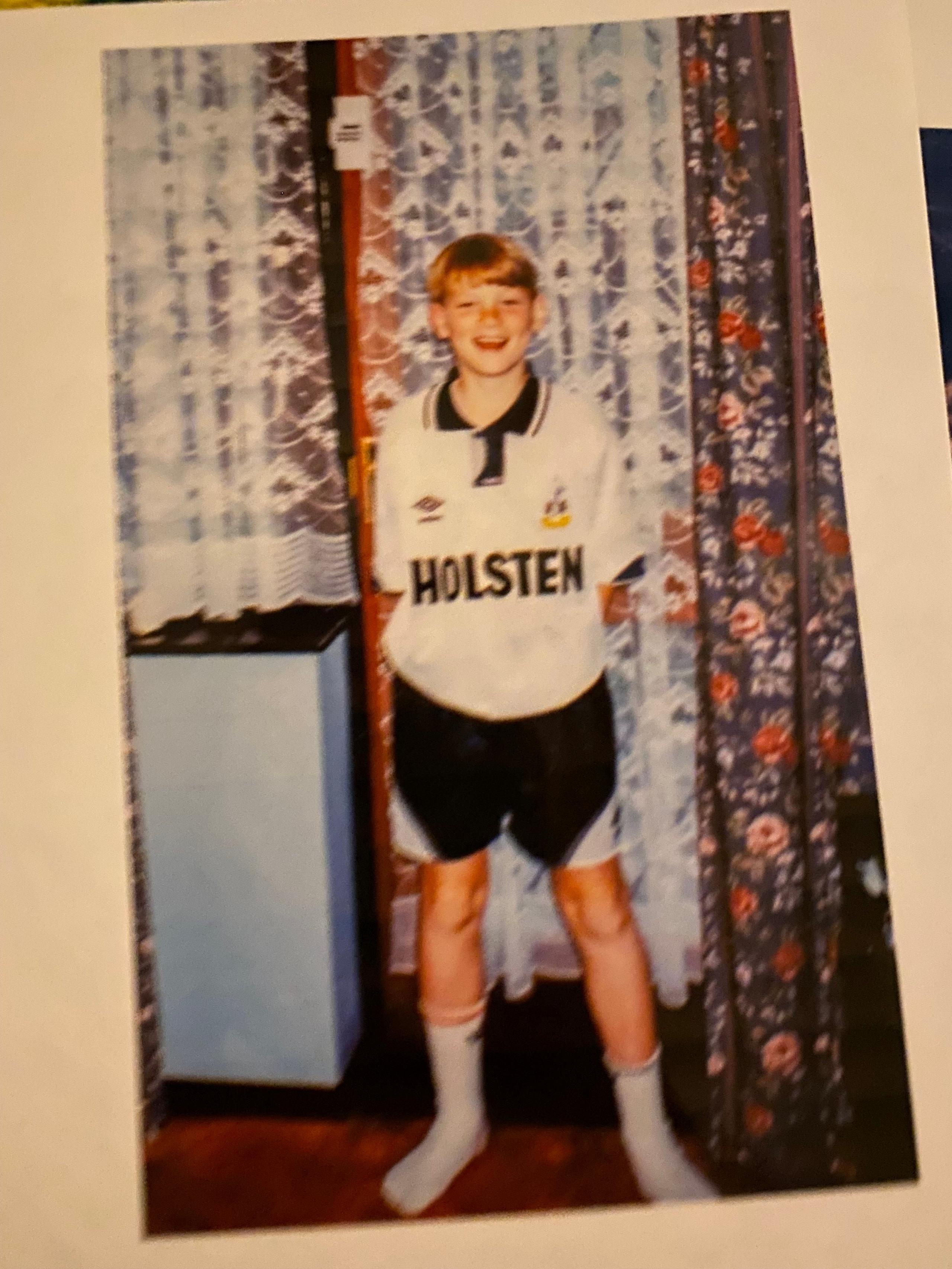 A picture of a child in a 1990s Tottenham home shirt