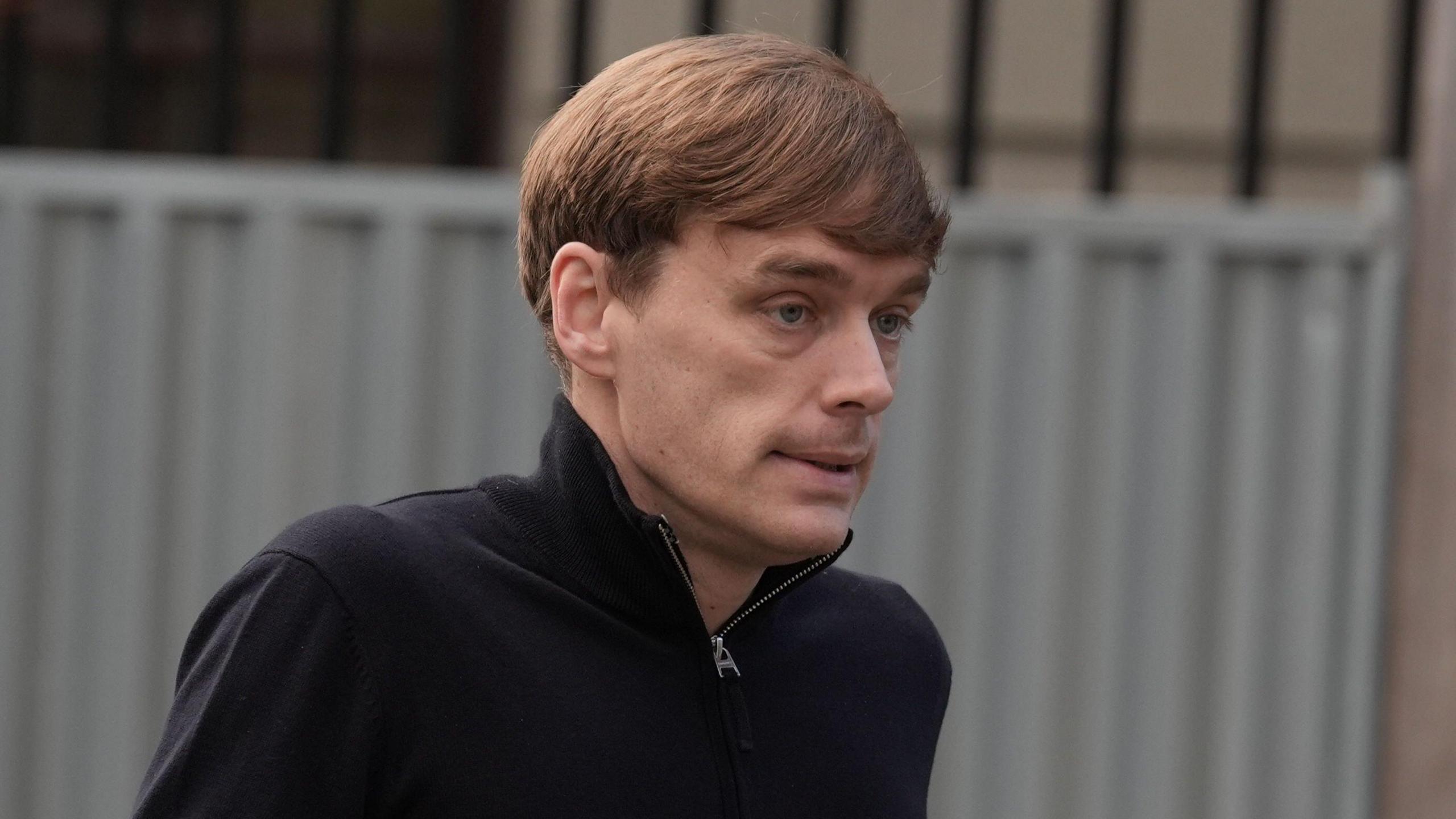 James Lawrence arriving at the High Court in Dublin for an earlier hearing in the case.   He has short, fair hair and is wearing a black top with a zip collar.