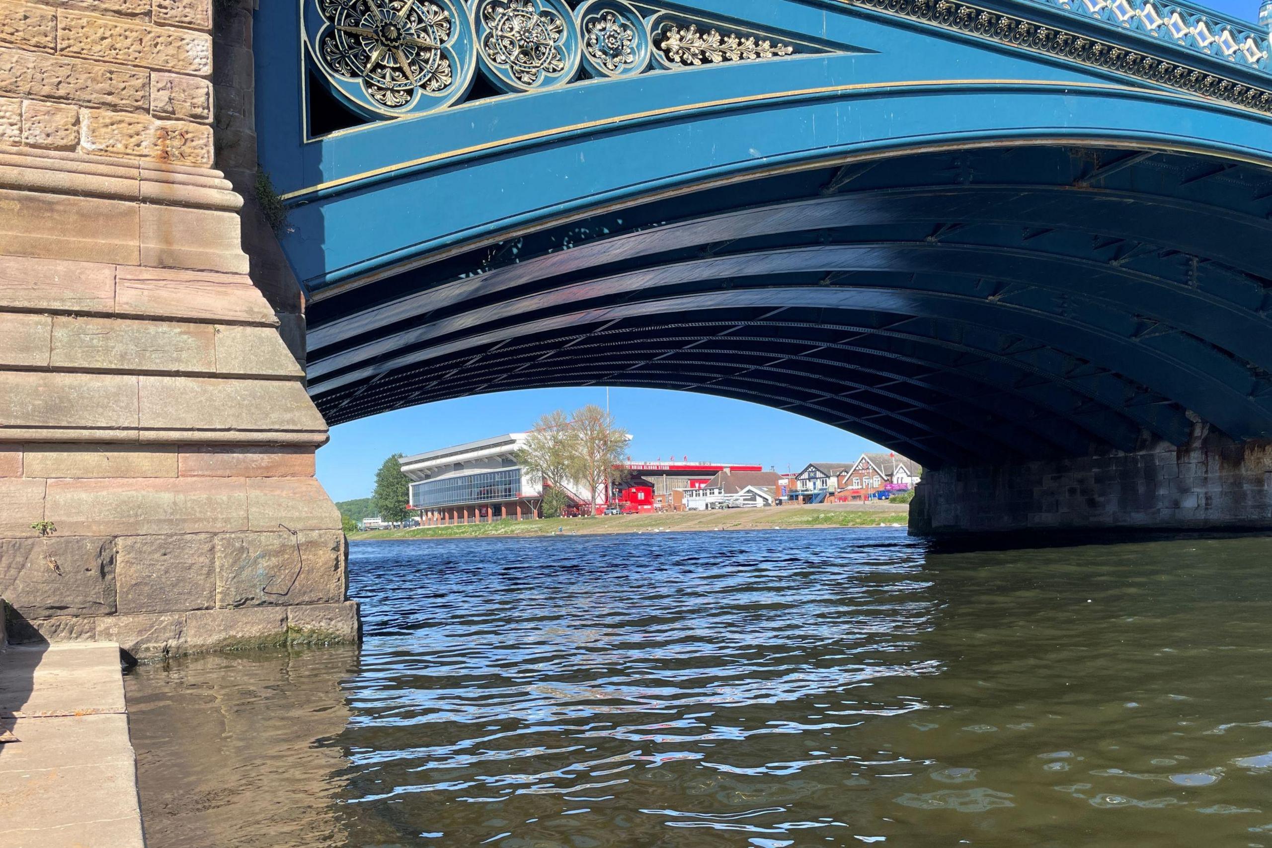 A view under an arch of Trent Bridge, with Nottingham Forest's City Ground in the background
