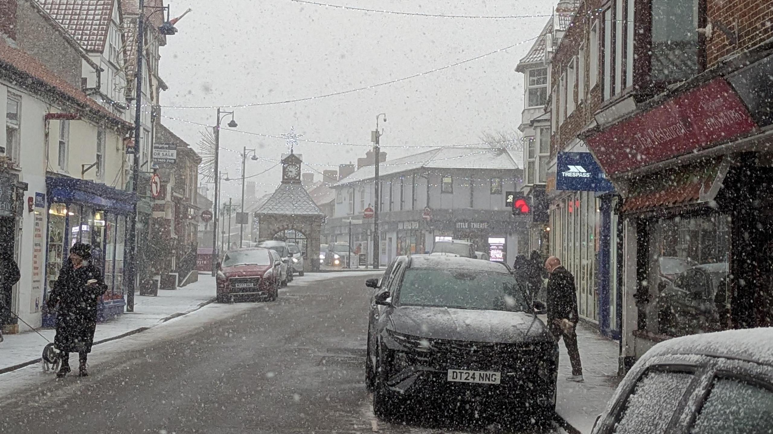 High street scene as heavy snow falls