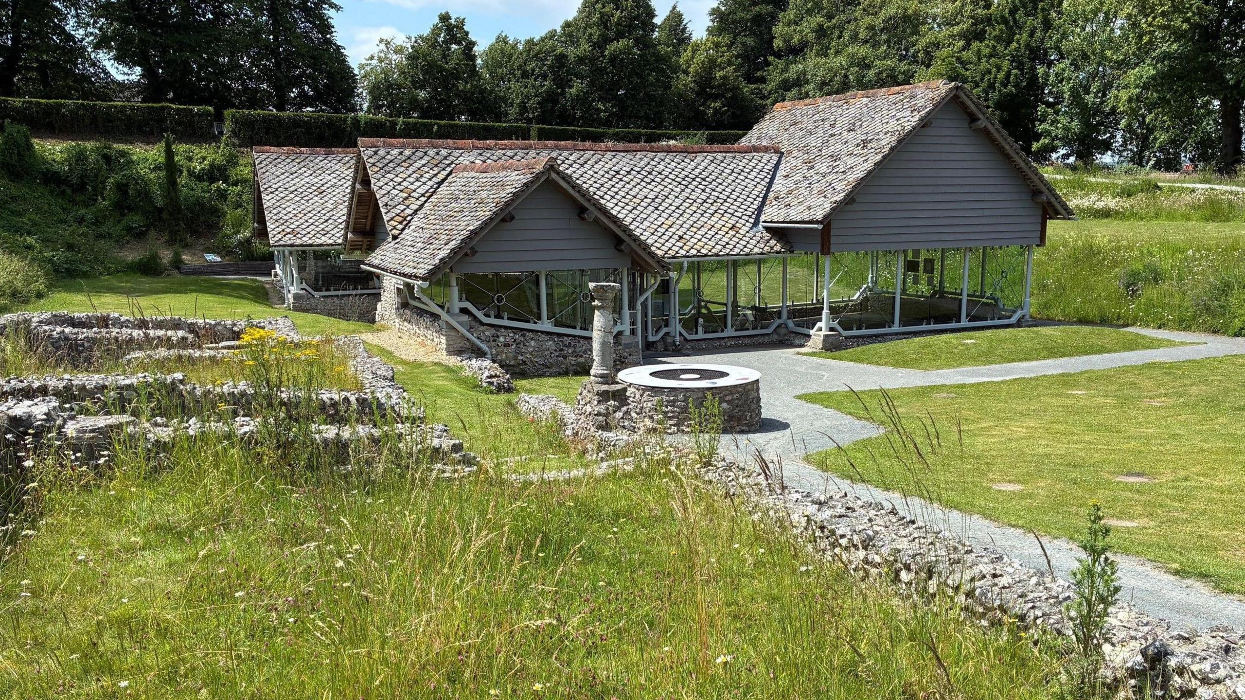 The Roman Town House site. The main part of the site has a modern covering. Low stone walls presumably delineate the layout of the old site.