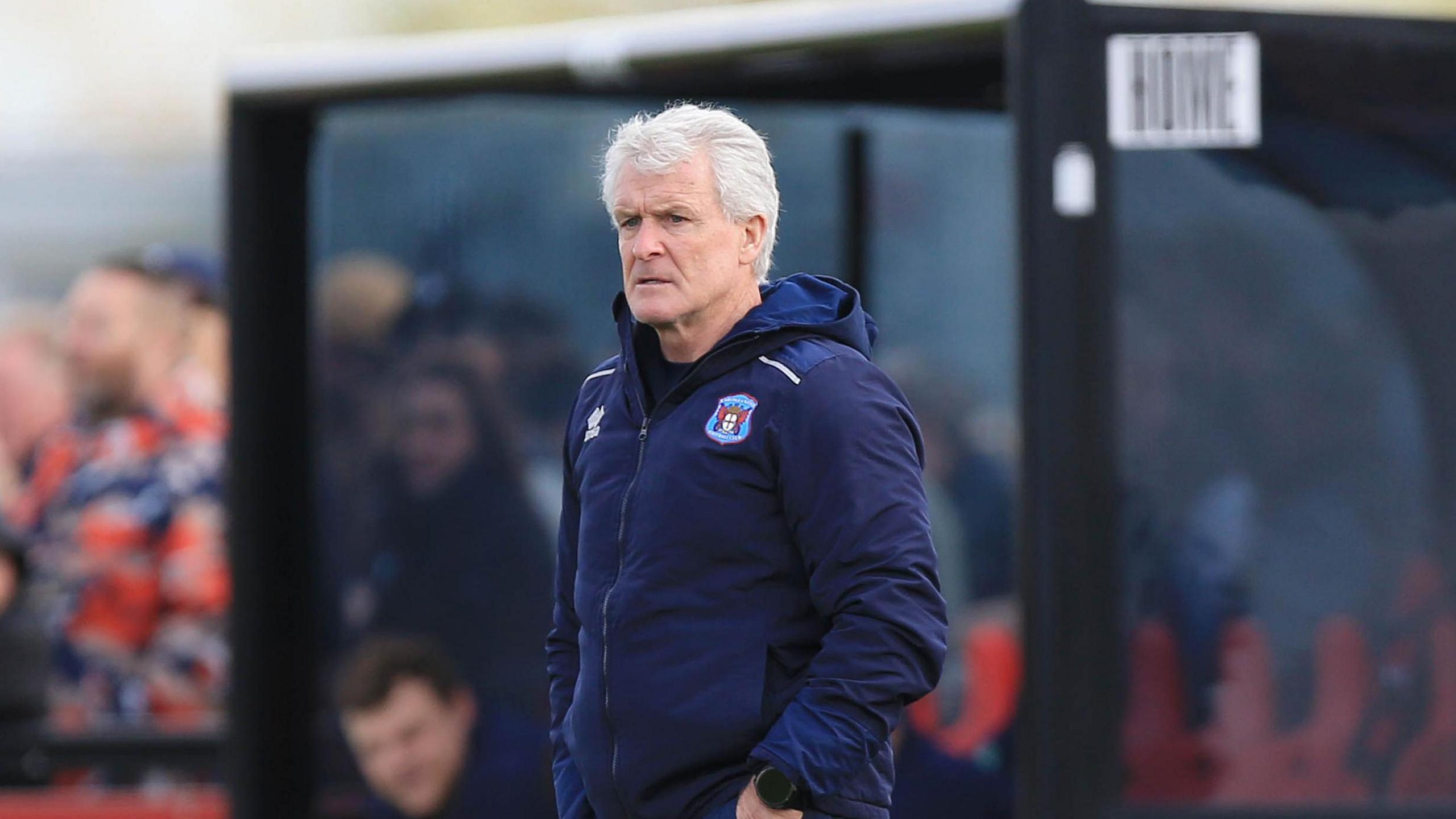 Mark Hughes in his Carlisle hooded jacket, stood on the touchline at Truro 