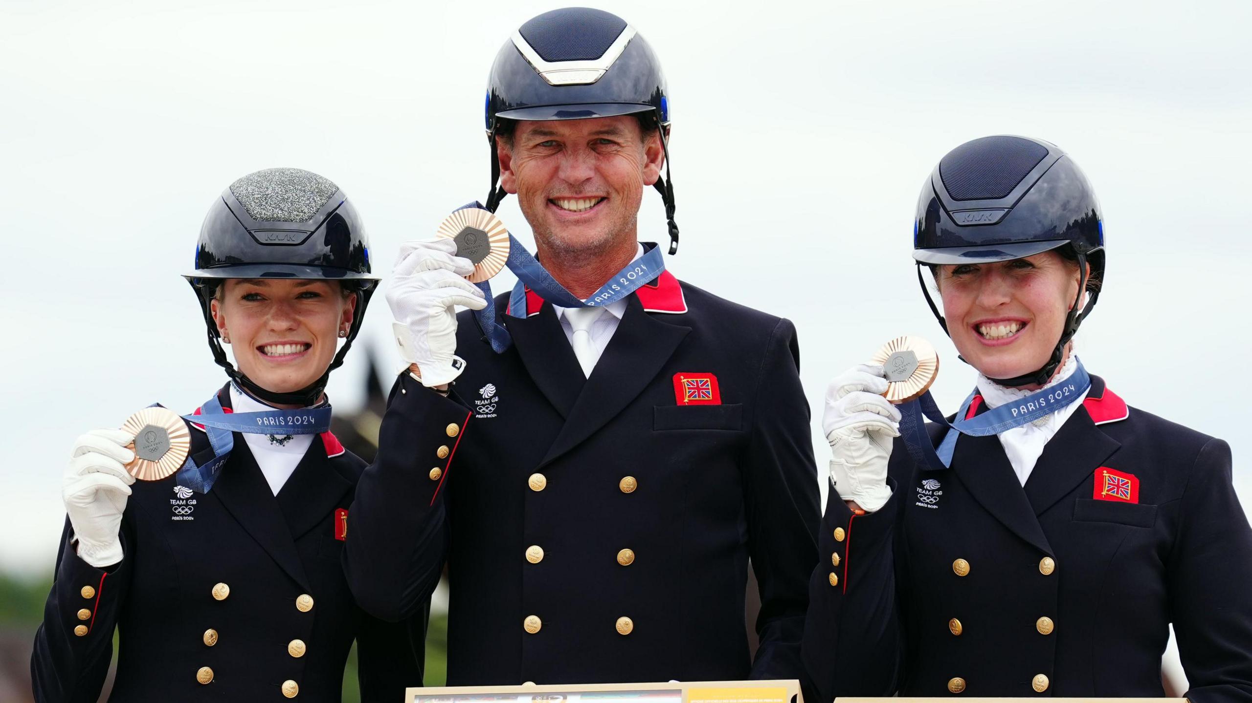 Carl Hester (centre), Charlotte Fry (left) and Becky Moody hold up their bronze medals at the last Olympic Games