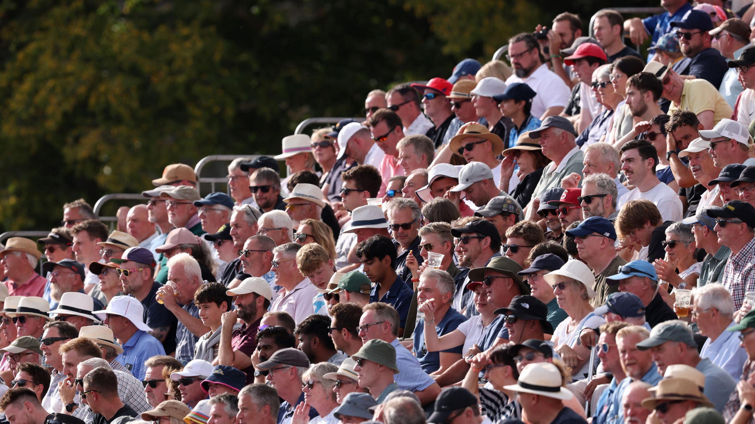 Crowds of people with sunhats on.