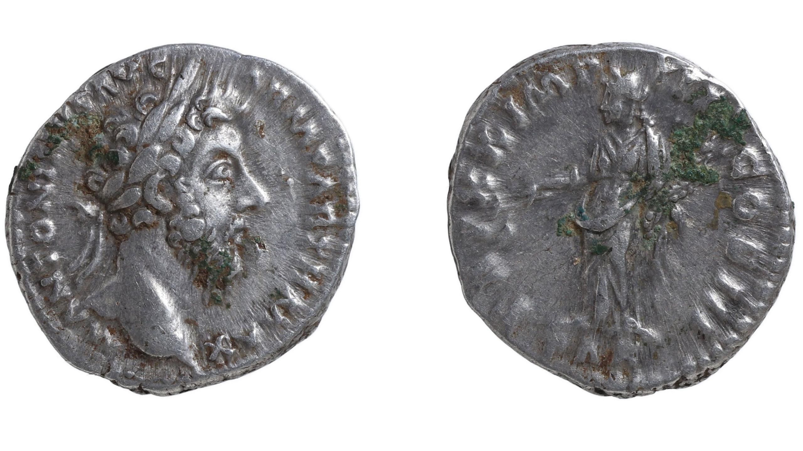 Two sides of a silver coin dating to AD120-1. On the left it shows the emperor Hadrian in profile, facing right. He had a prominent nose and eye and has a short but full beard. On his curling hair is a laurel wreath. There are letters struck on the circumference of the coin. On the right is its other side, which is much more worn. It shows the female figure of Pax, dressed in robes and facing left. Some of the letters on its circumference are indistinct.