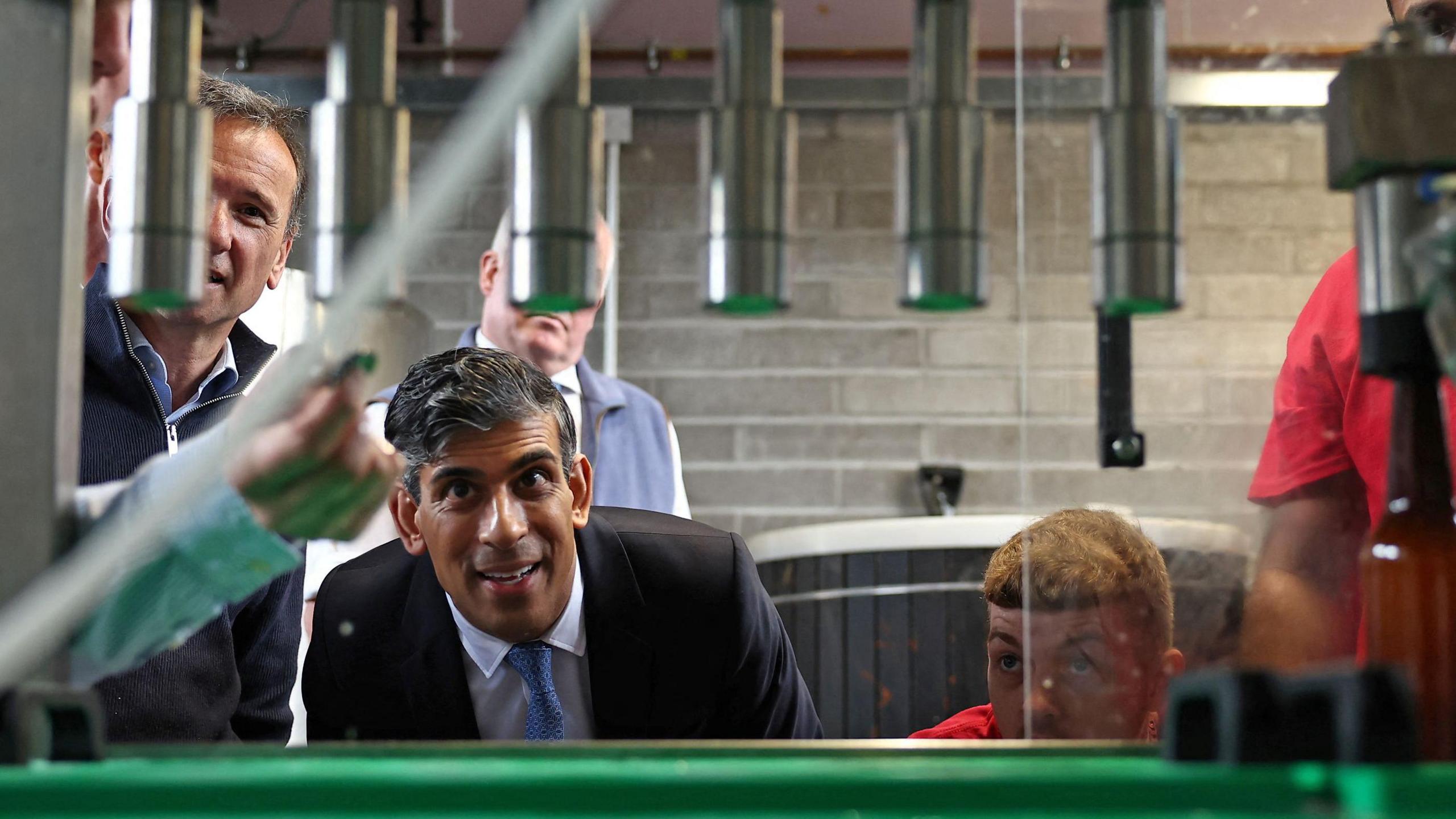 Rishi Sunak and Vale of Glamorgan MP Alun Cairns are shown a bottling machine during a visit to the Vale of Glamorgan Brewery,