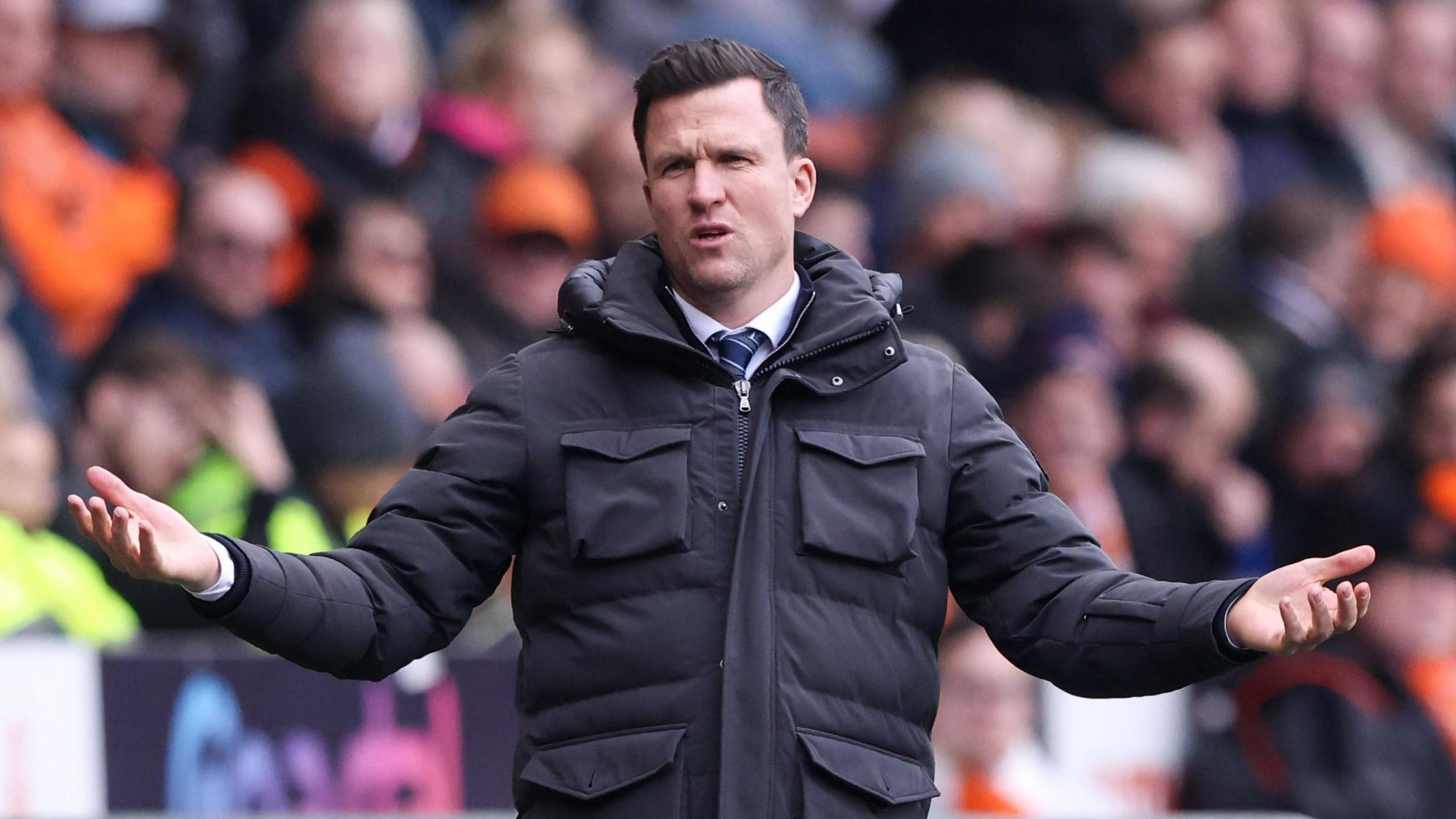 Gary Caldwell with his arms outstretched in the Wigan technical area