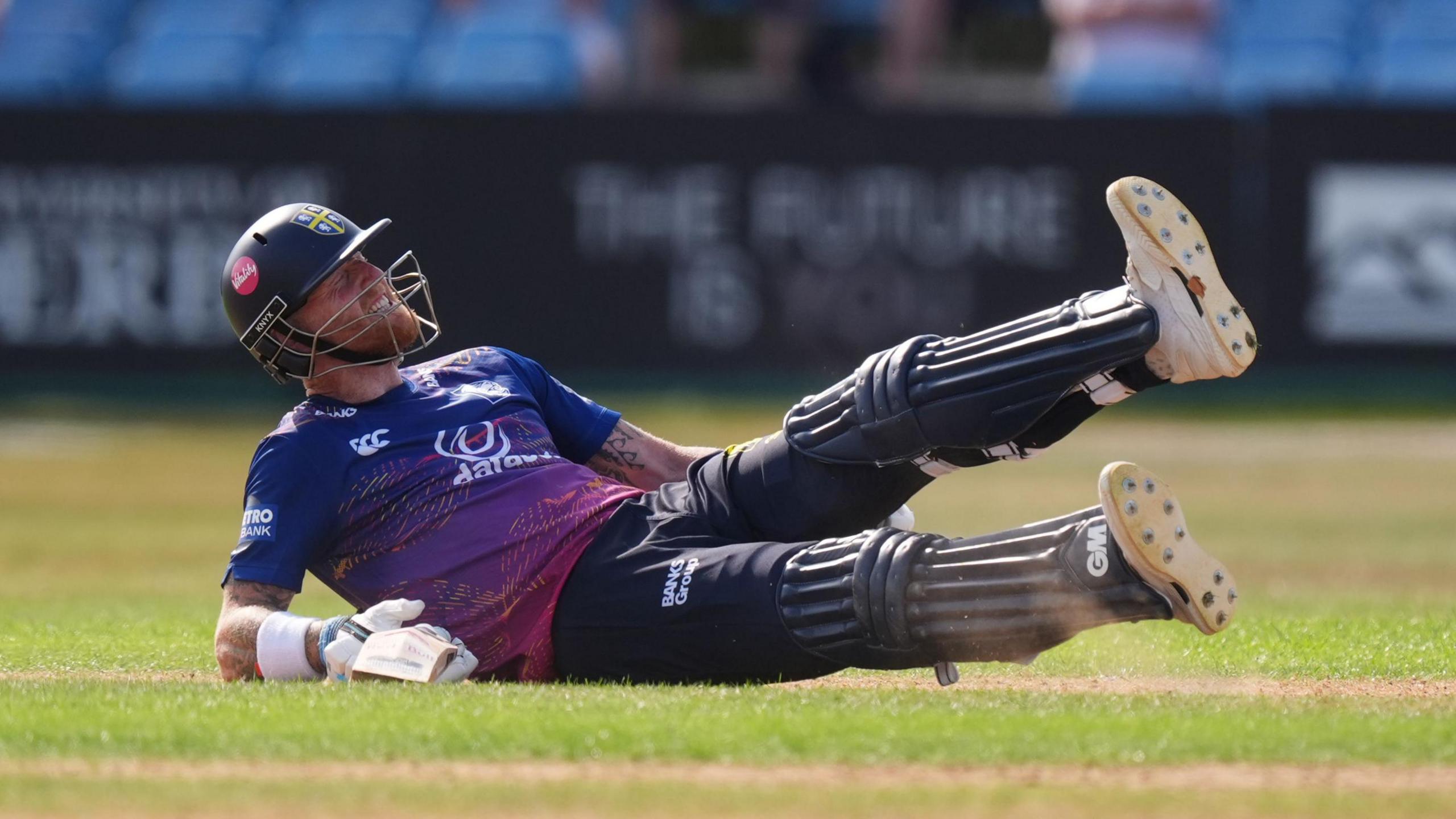 Ben Stokes is on the ground clutching the back of his left leg in pain during his innings for Durham.