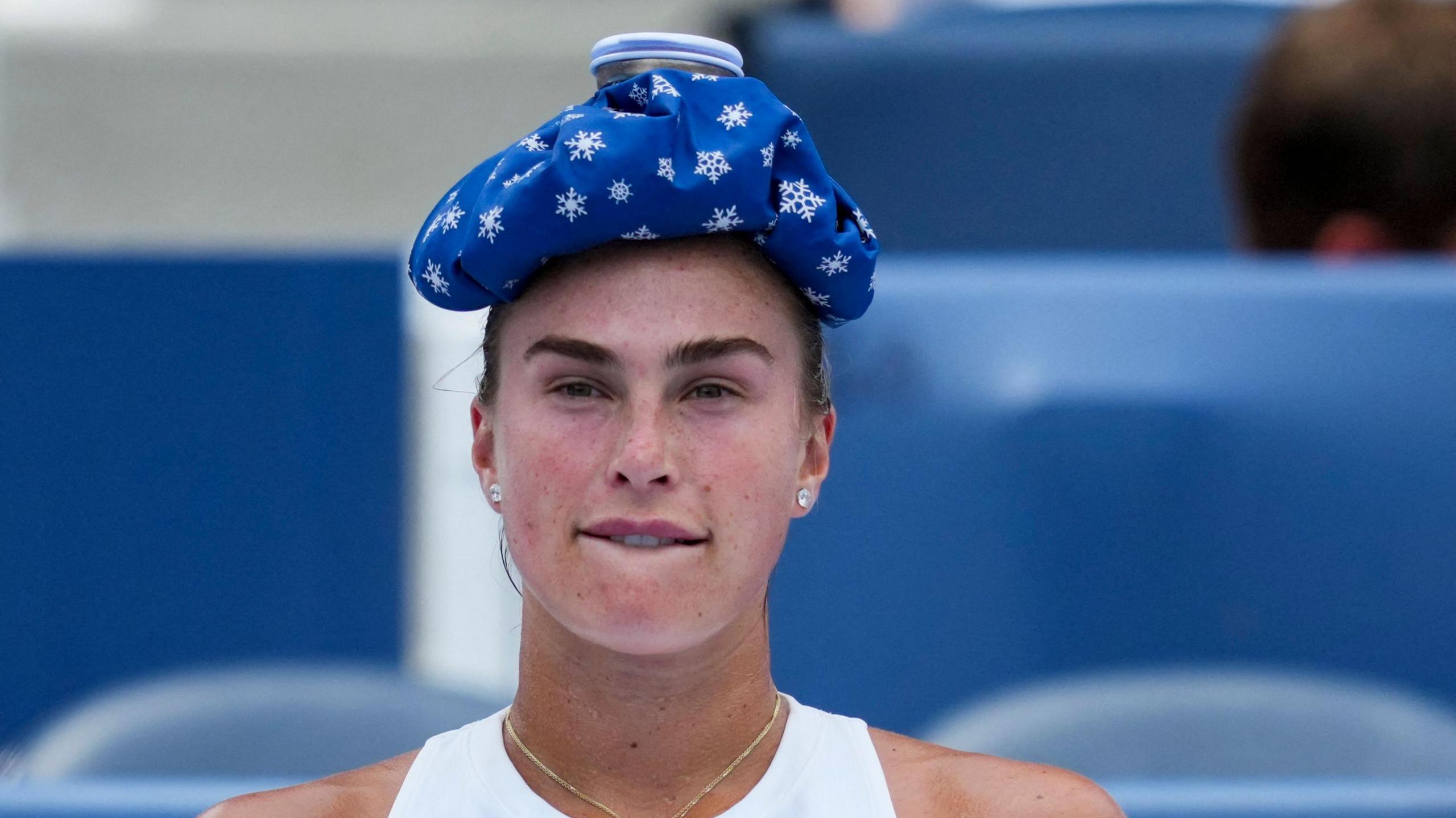 Aryna Sabalenka puts a ice towel on her head