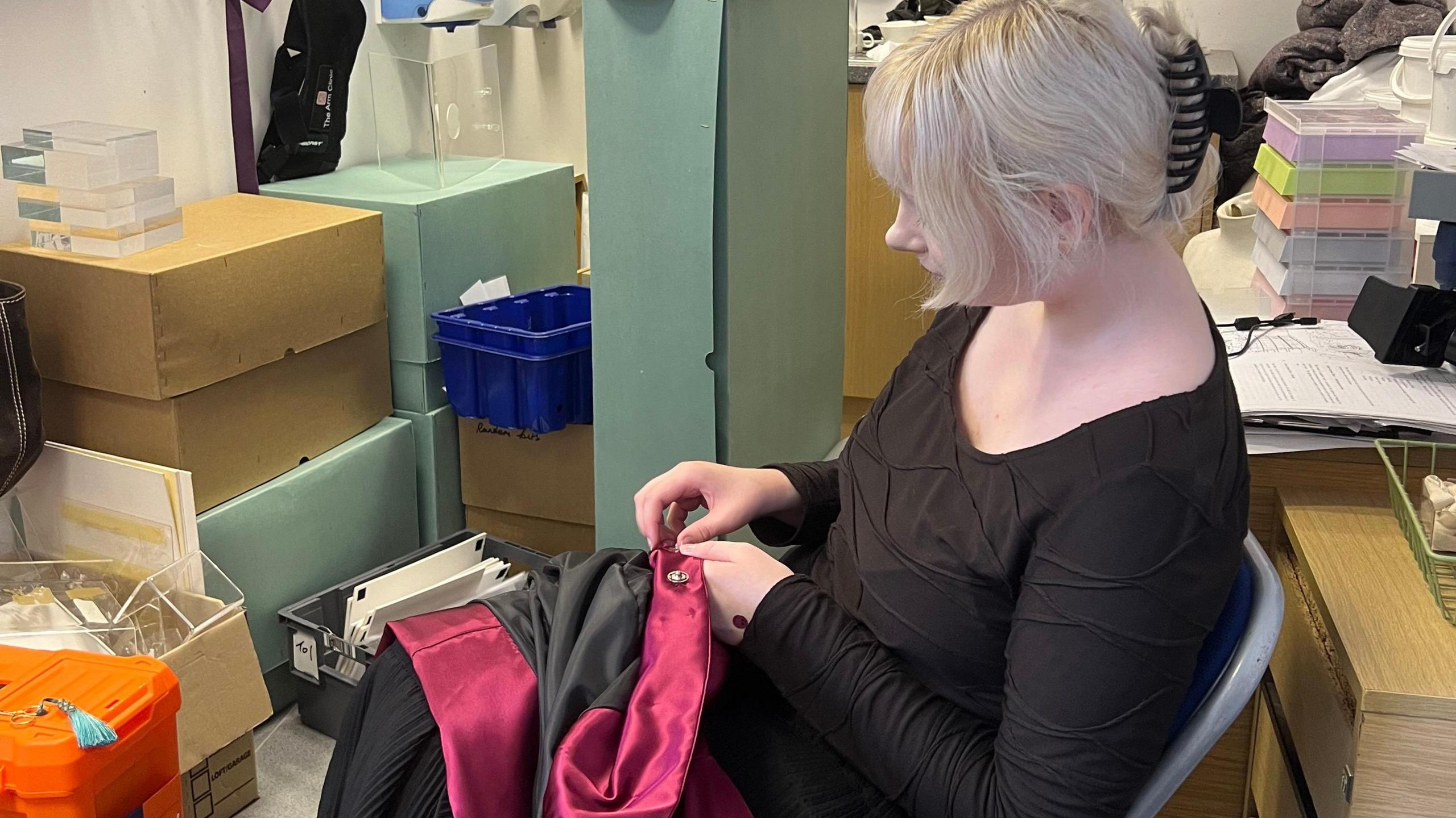 A volunteer working on a fabric loaned for the exhibition