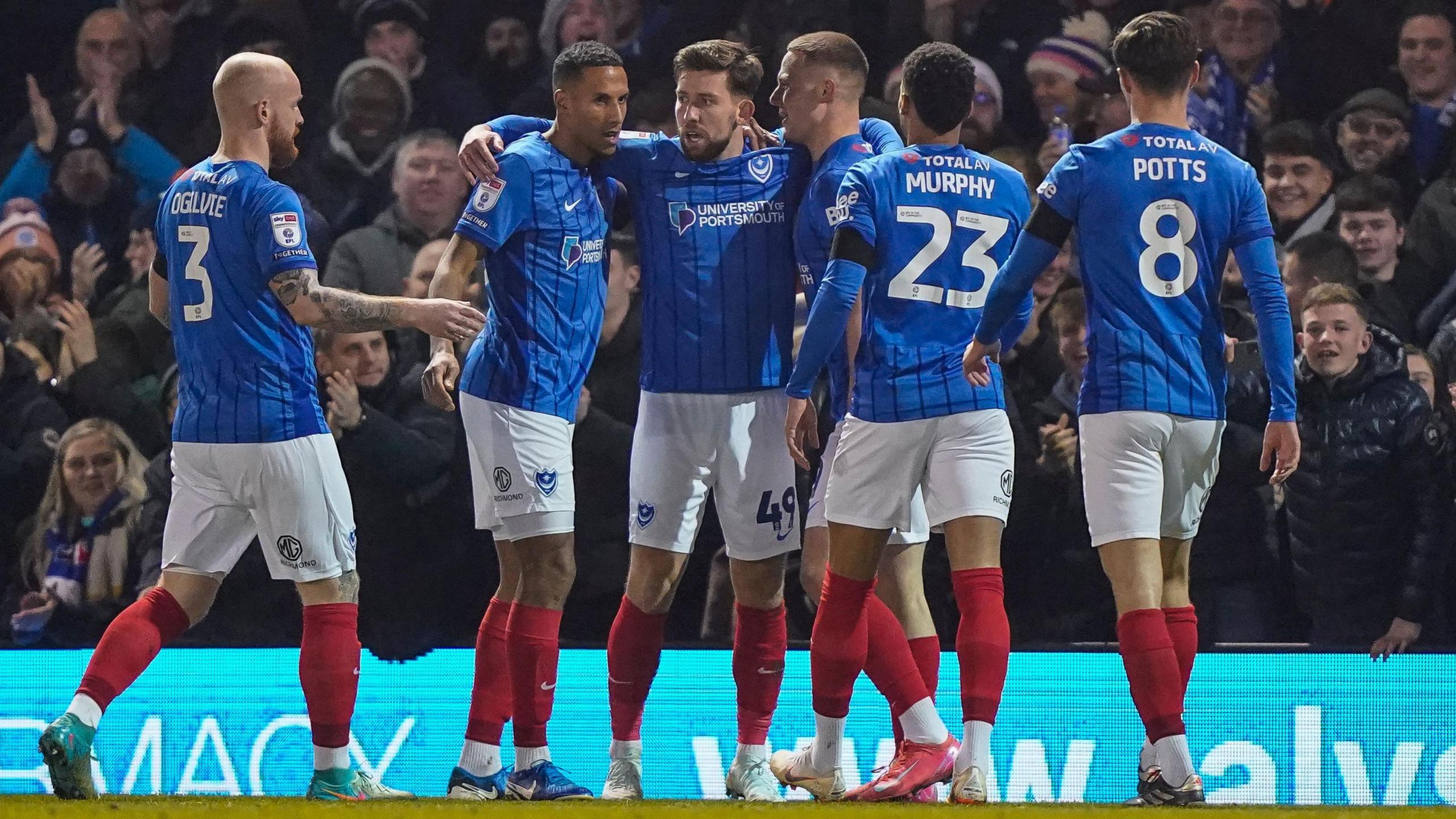 Portsmouth players celebrate with Callum Lang following his goal against Stoke