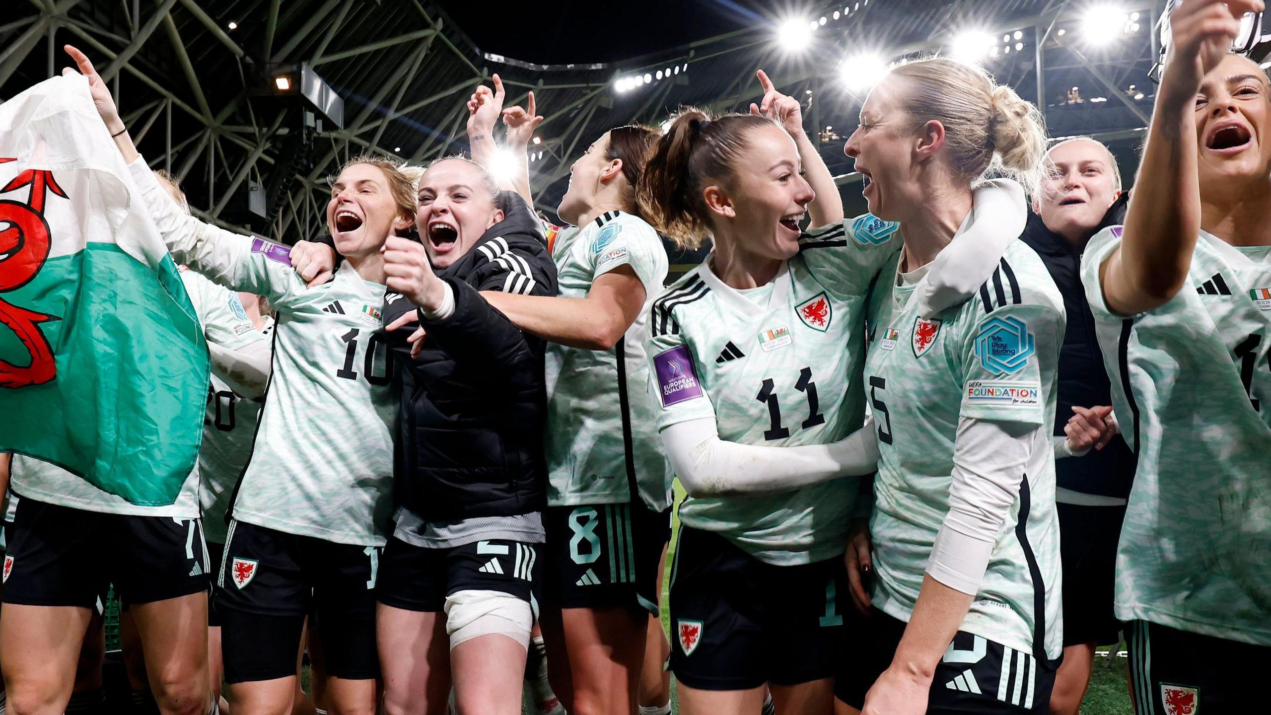 Hannah Cain, Rhiannon Roberts, Jess Fishlock, and other Wales teammates celebrate their victory over Republic of Ireland at the Euro 2025 qualifier playoffs.