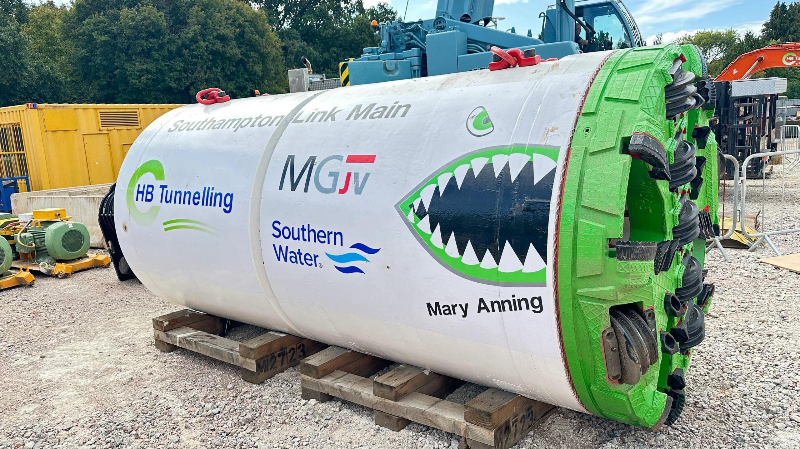 A tubular tunnelling device with Mary Anning written on it and some cartoon teeth printed on it