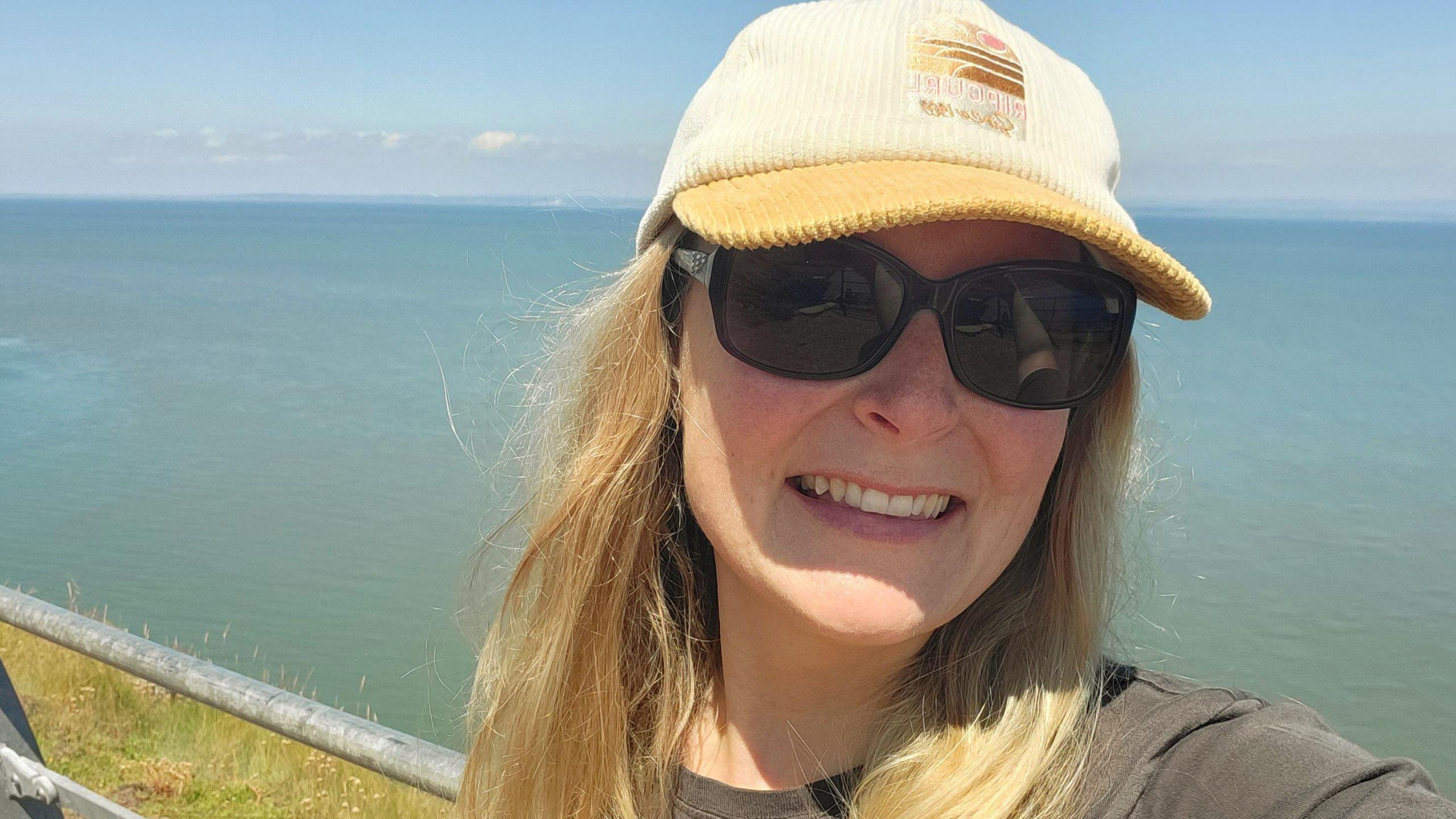 Louise at Hurlestone Point wearing a cap and sunglasses