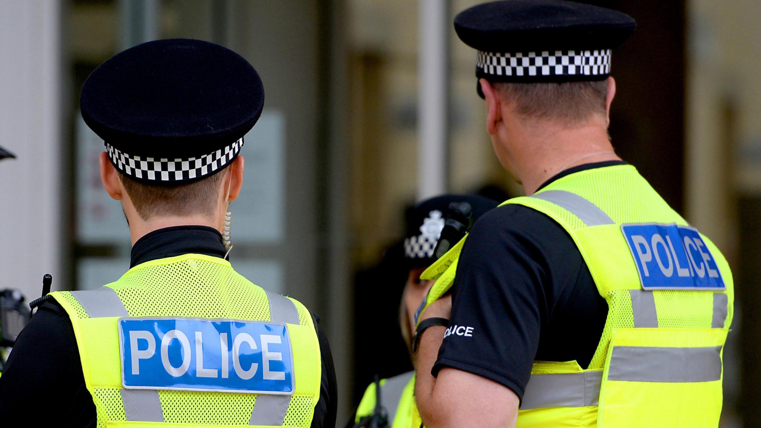 Stock image of three police officers wearing high-vis jackets