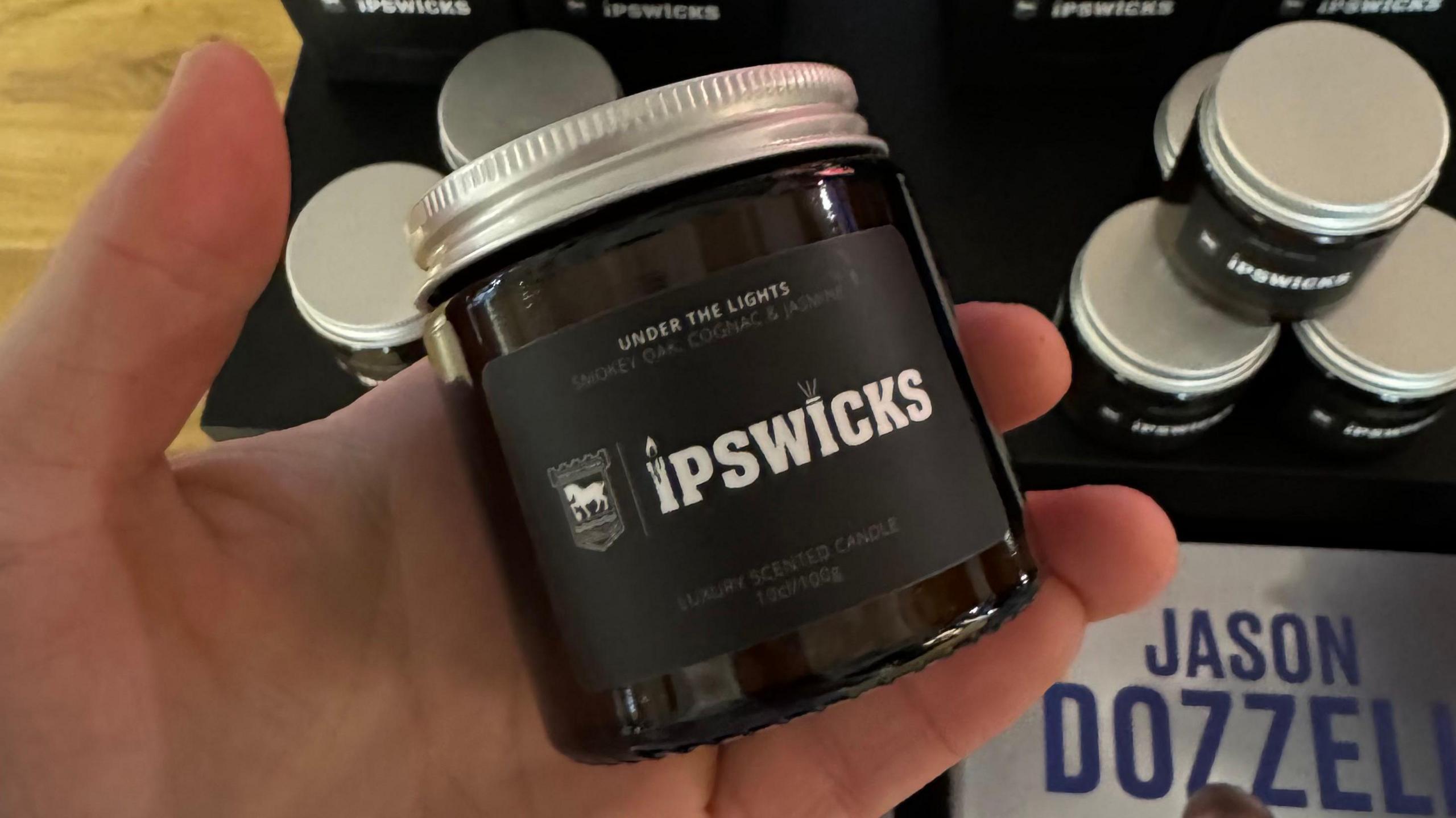 A hand holding an Ipswich Town candle