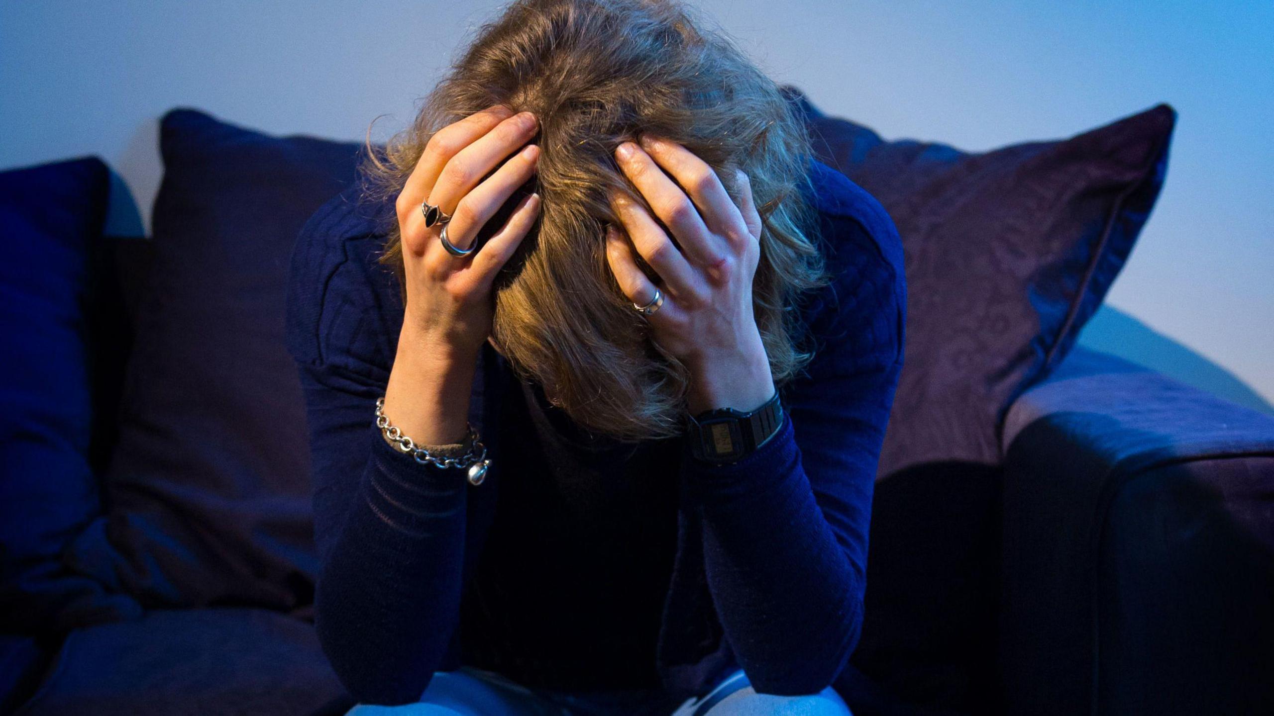 Woman holding her head with her hands