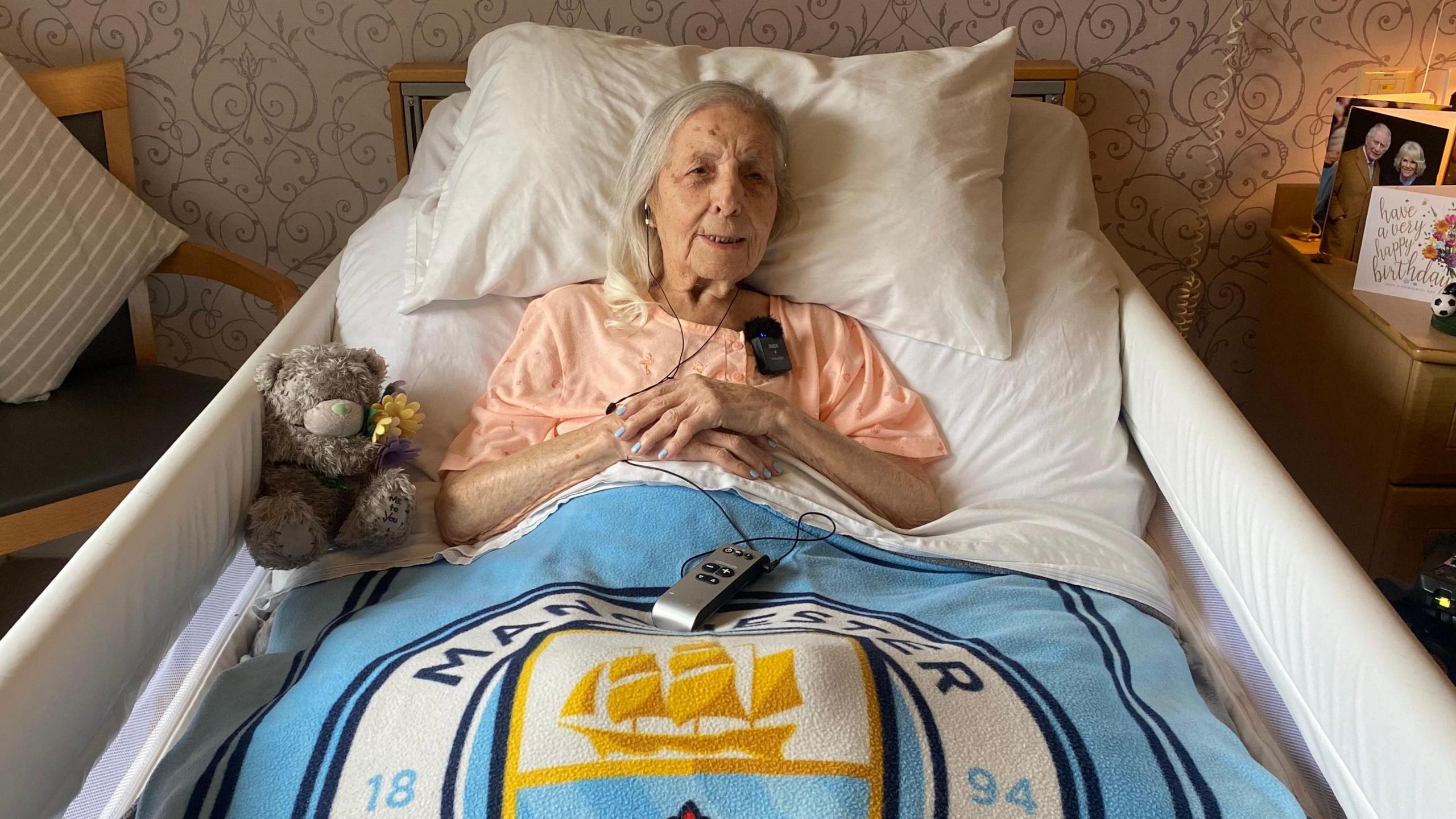 Mary Spiers in bed with her Manchester City blanket and birthday cards.