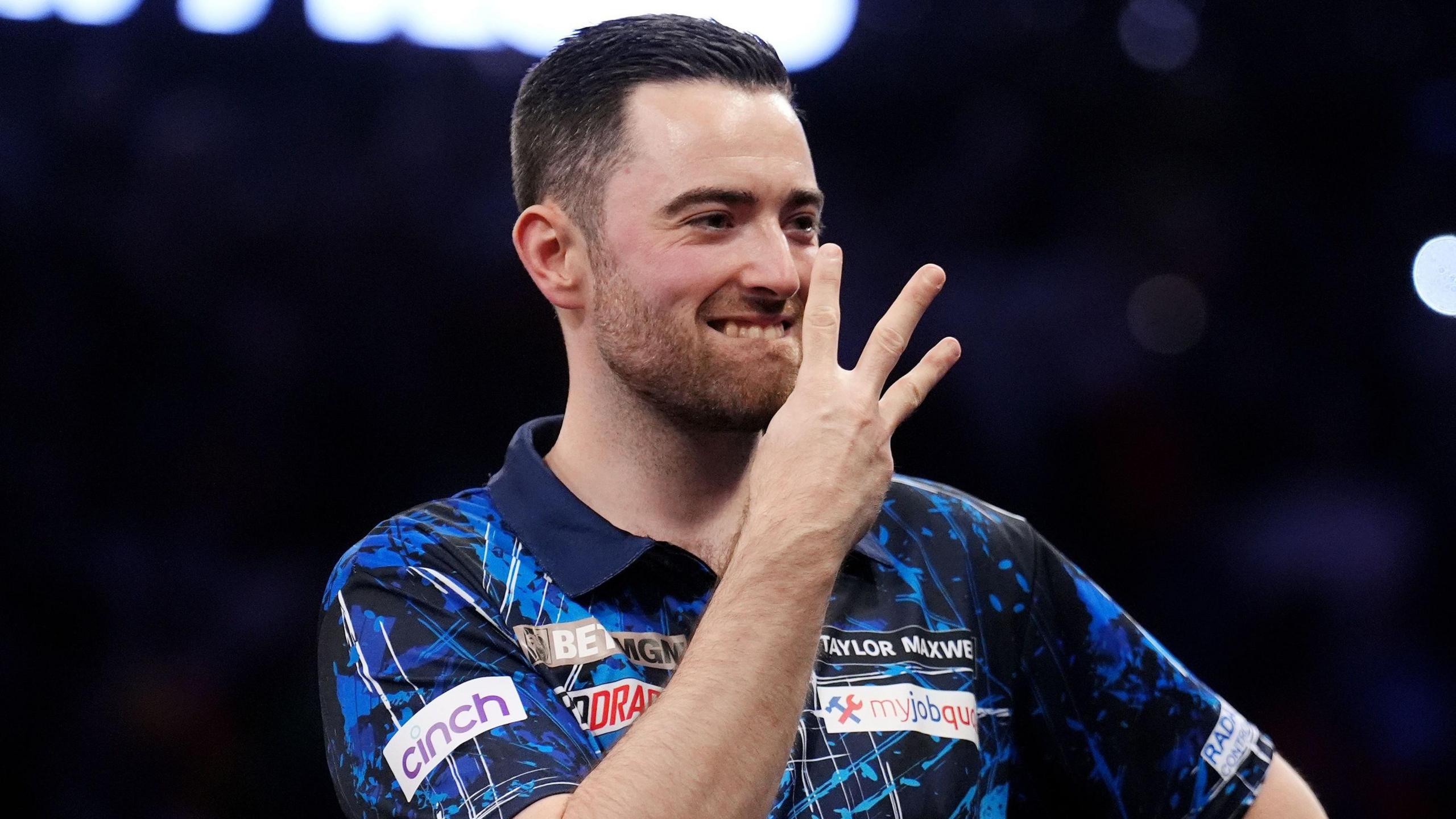 Luke Humphries celebrates winning the final of Premier League Darts against Luke Littler by gesturing he has now completed the triple crown of the World Championship, World Matchplay and Premier League