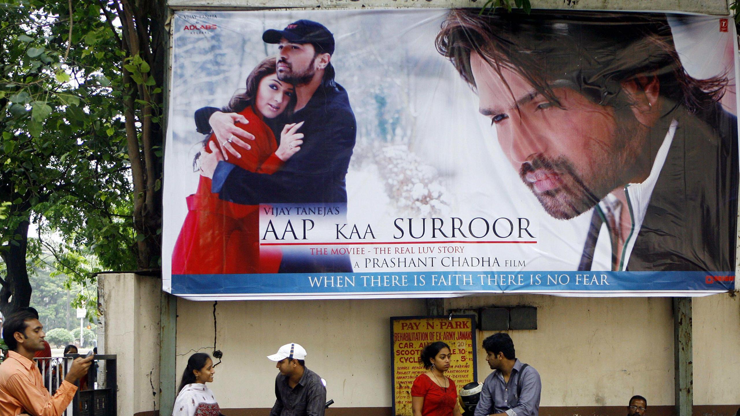 Couples stand under a hoarding advertising Bollywood box-office hit movie "Aap Kaa Surroor" (Your intoxication) in Mumbai, 07 July 2007.