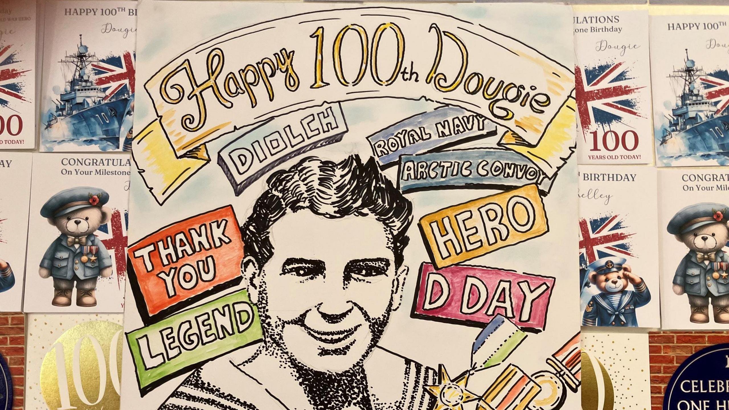 One of Doug's cards.  It says 'Happy 100th Dougie' written on it.  Other cards can be seen alongside it.