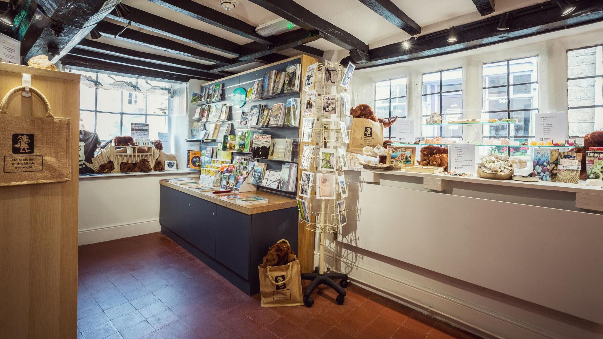 The shop inside the heritage centre where many items for sale are on display on shelves and in a window. 