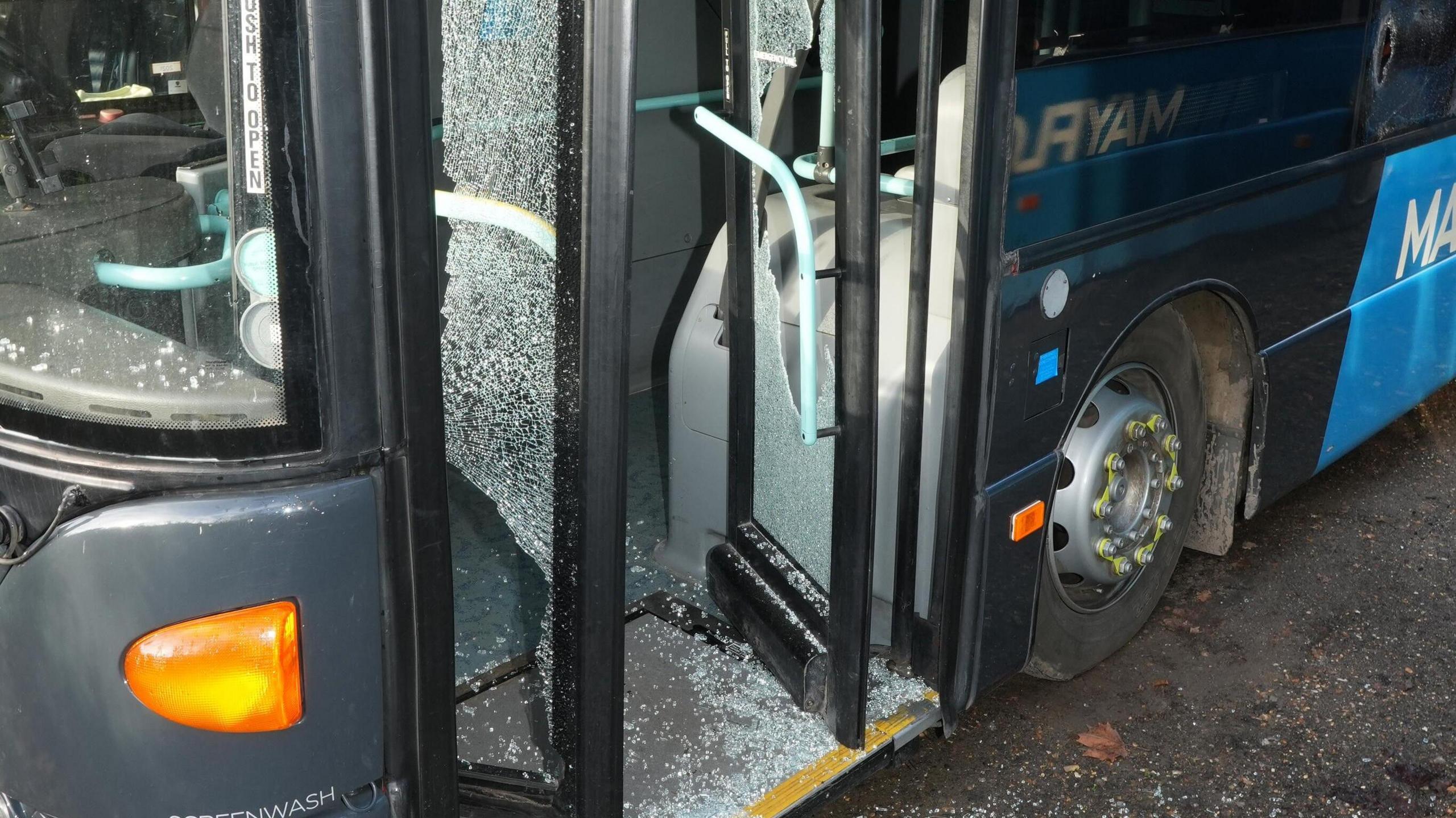 A close-up of smashed glass in a bus door