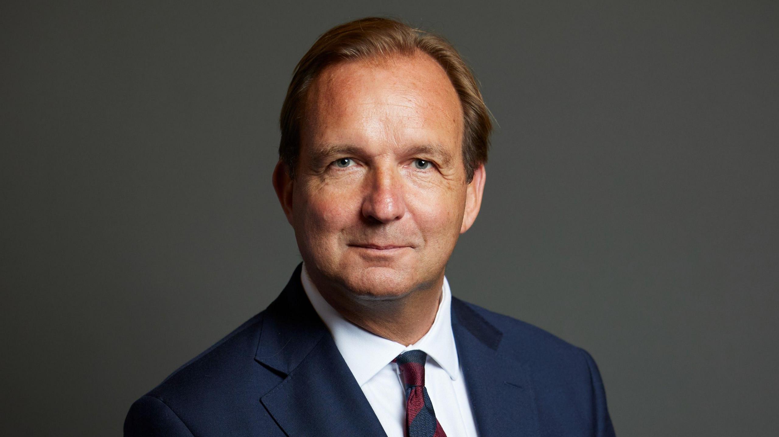 The official portrait of Lincoln Jopp, who wears a dark jacket and tie and white shirt.
