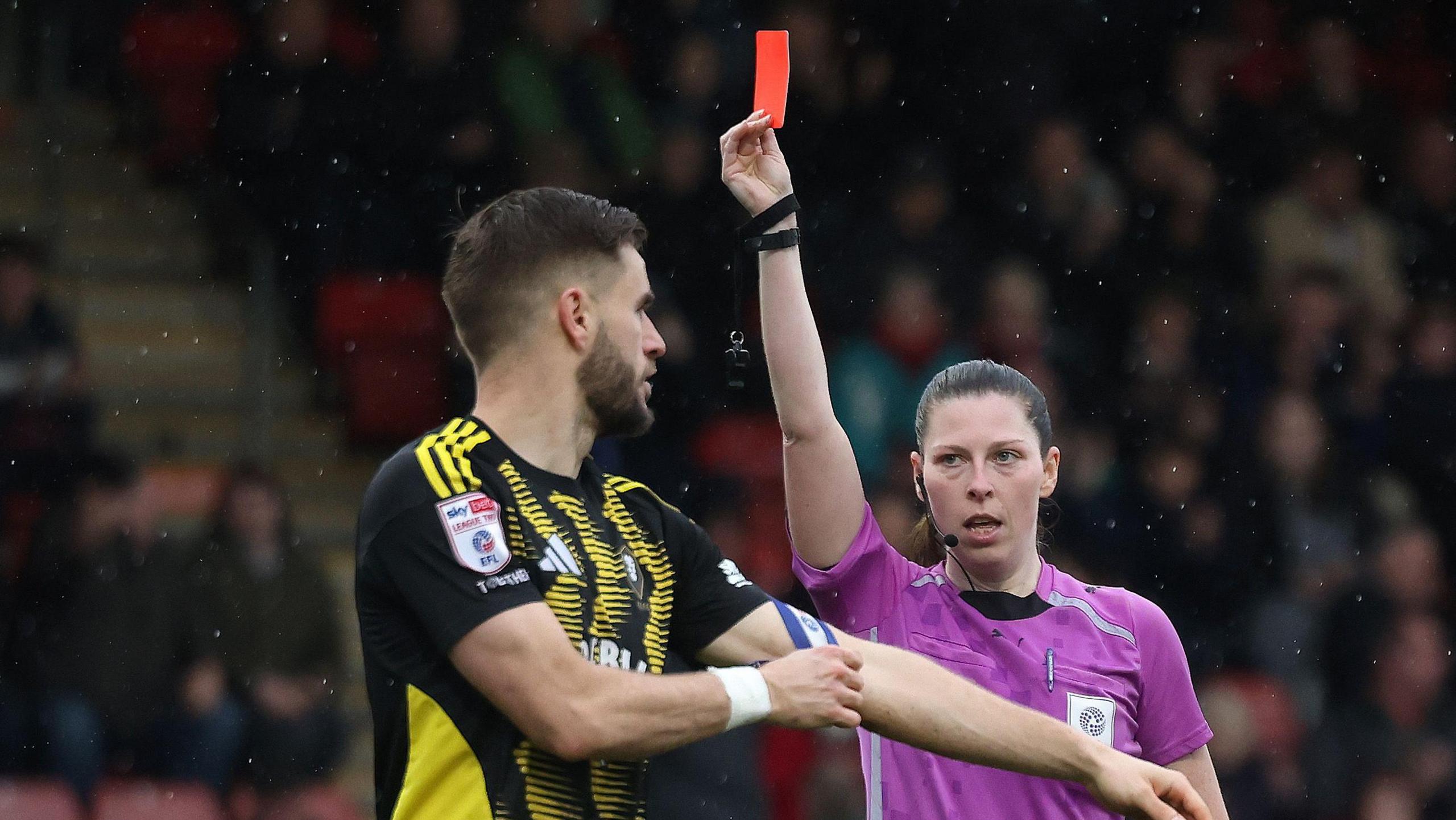 Referee Abigail Byrne gives a red card to Salford's Luke Garbutt