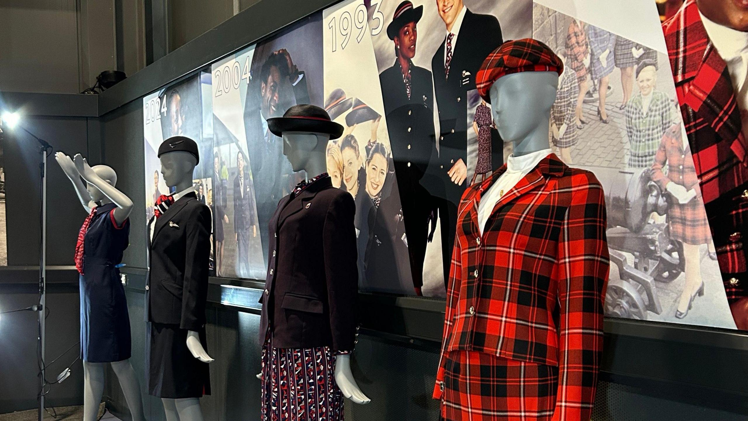 The image shows four mannequins dressed in the classic designs spanning decades. In the foreground, the mannequin is wearing the entirely tartan uniform.