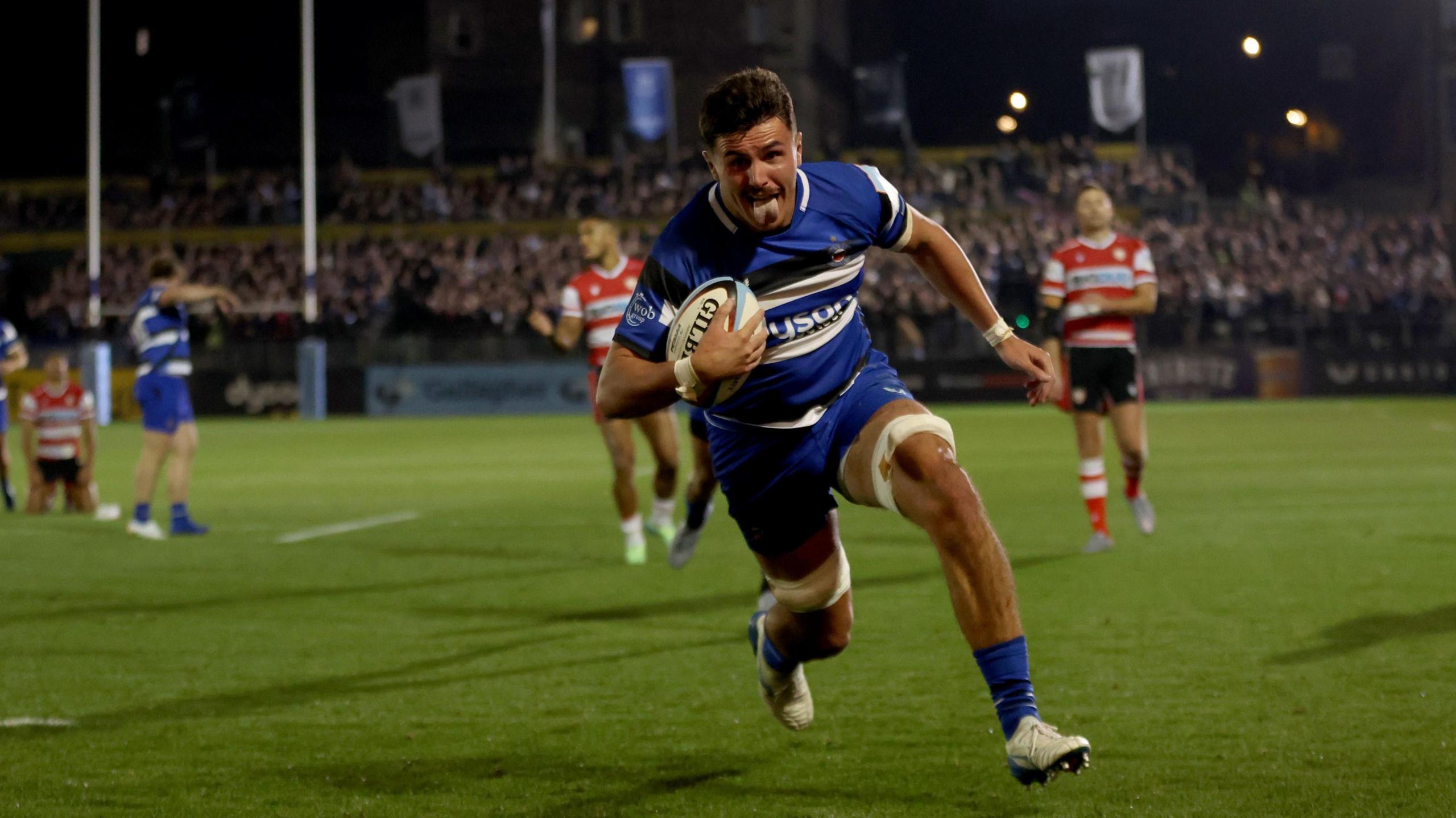 Ewan Richards of Bath sticks his tongue out as he runs unchallenged towards the camera to score a try as Bath play Gloucester at the Rec.