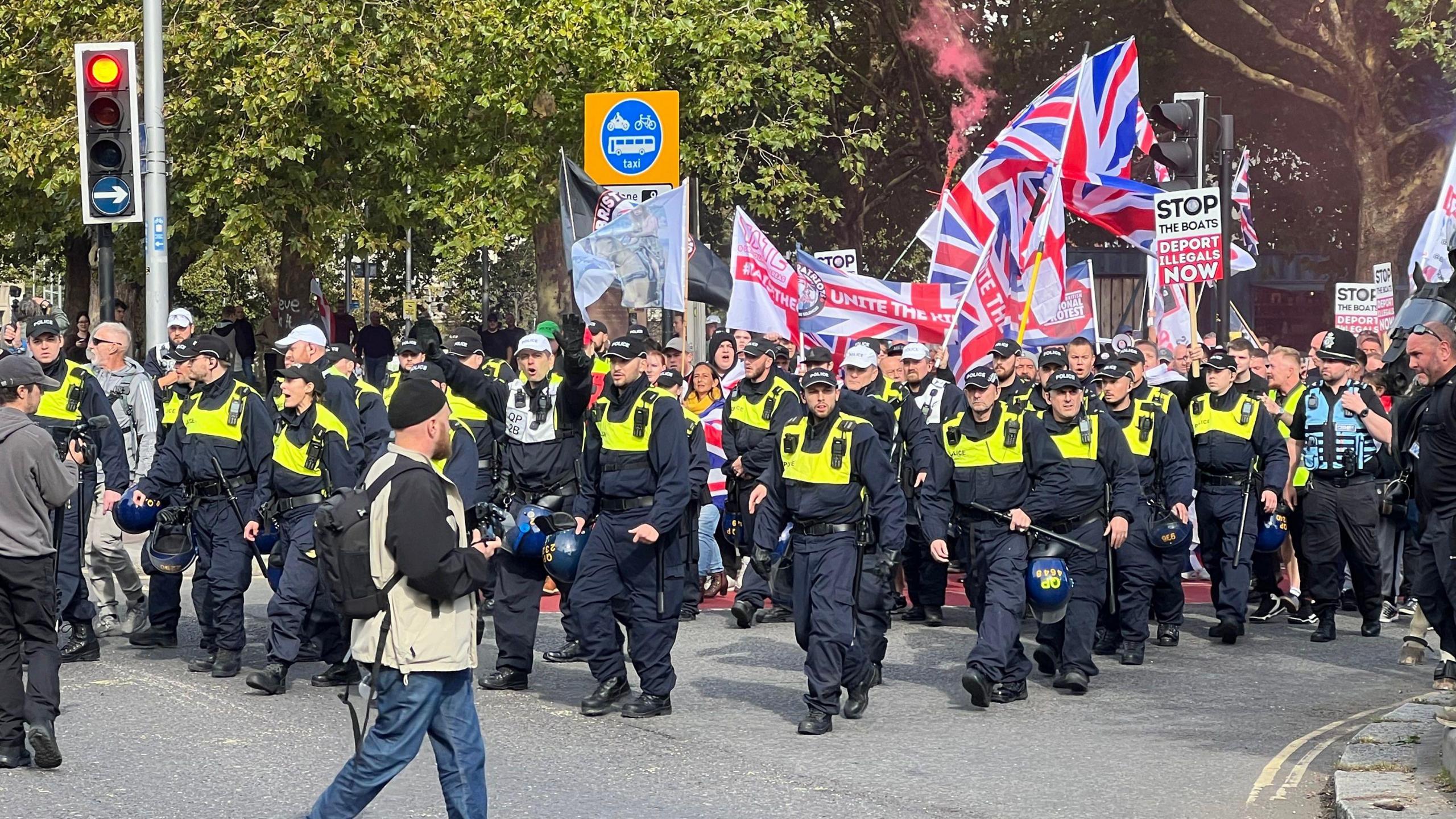 Lots of police officers on foot at the head of the protest march