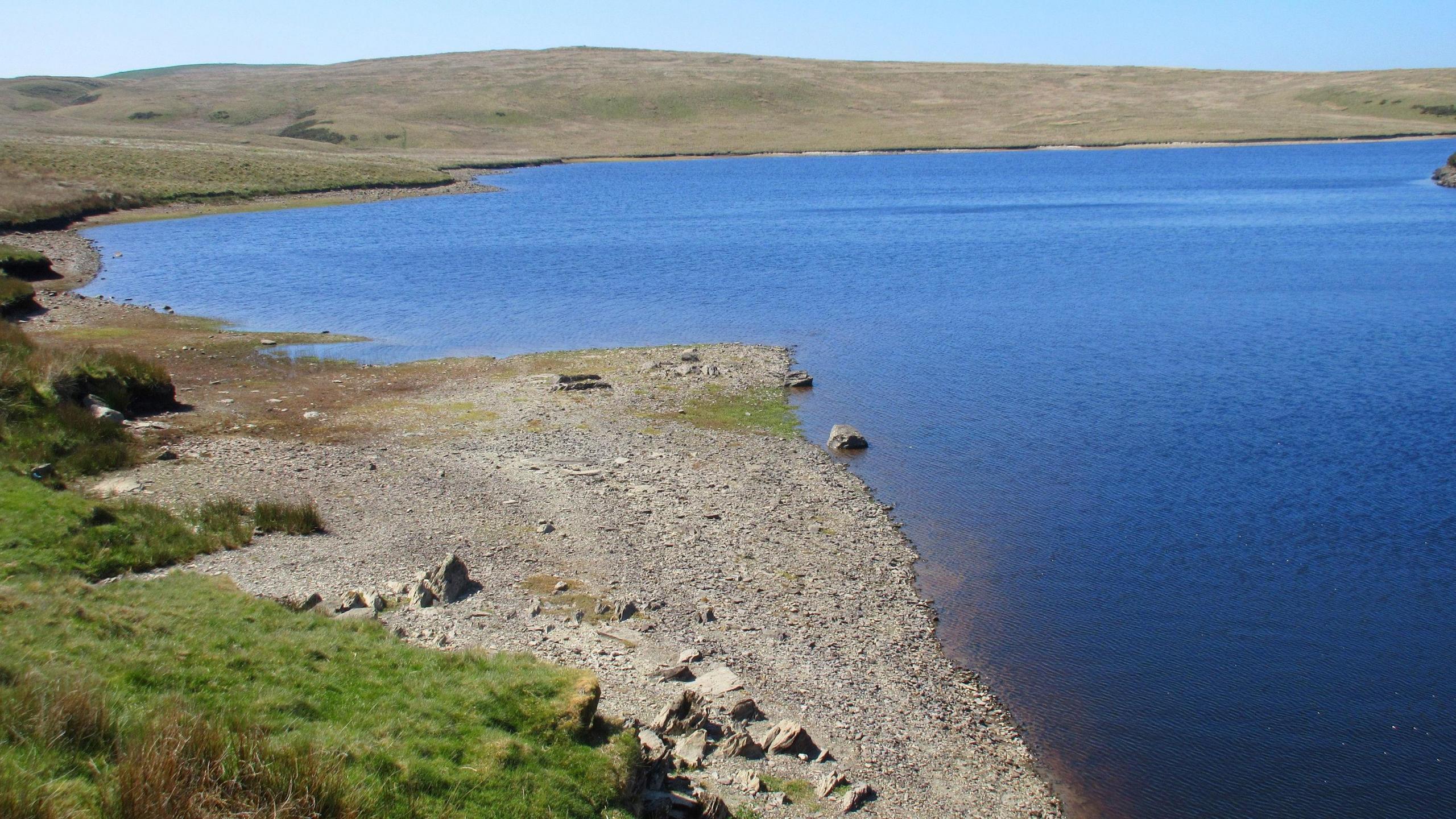 A rocky beach reveals lower than average water levels at Llyn Aled Isaf reservoir on Mynydd Hiraethog in Conwy county.
