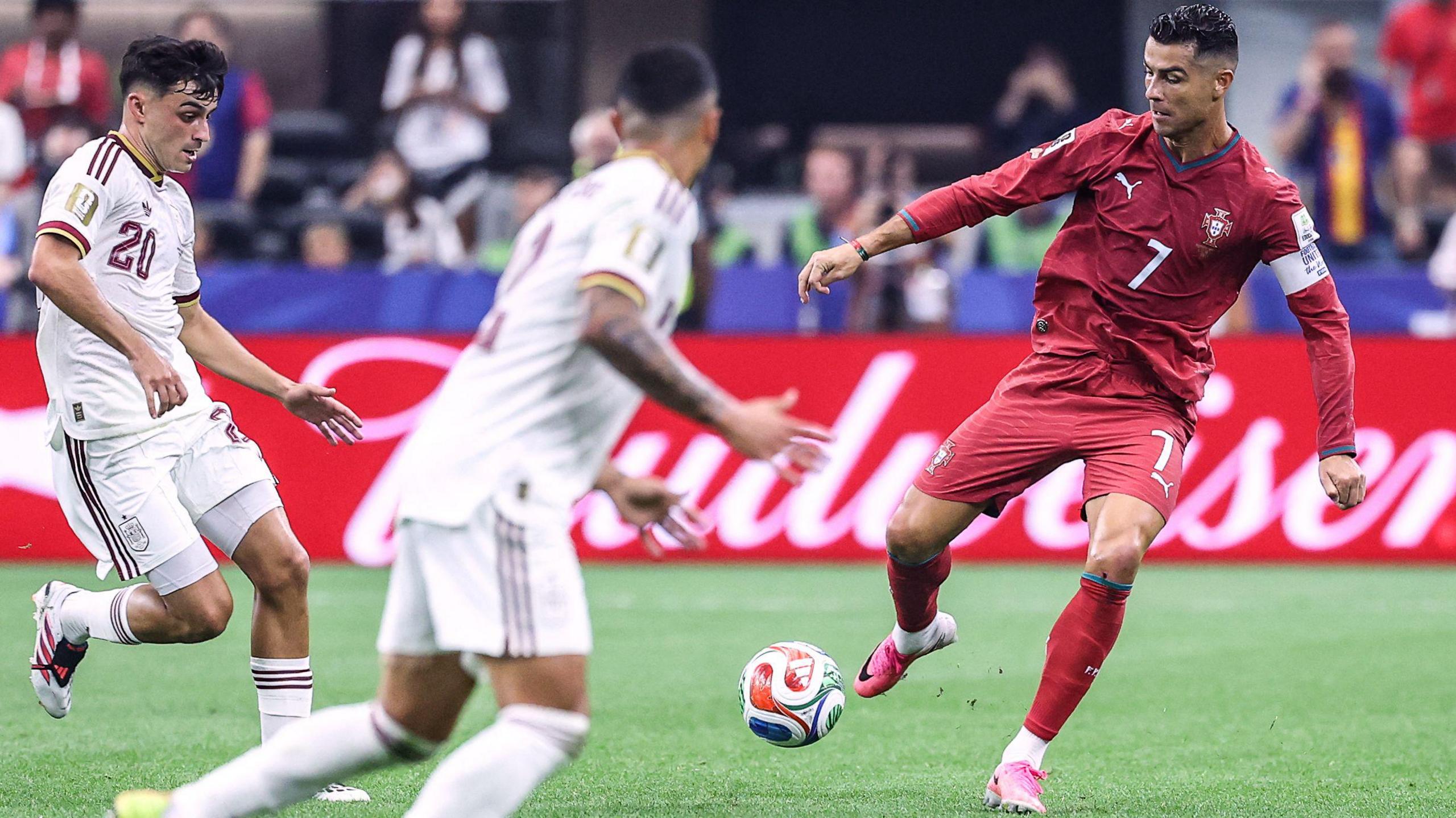 Portugal's forward Cristiano Ronaldo runs with the ball past Spain's midfielder Pedri
