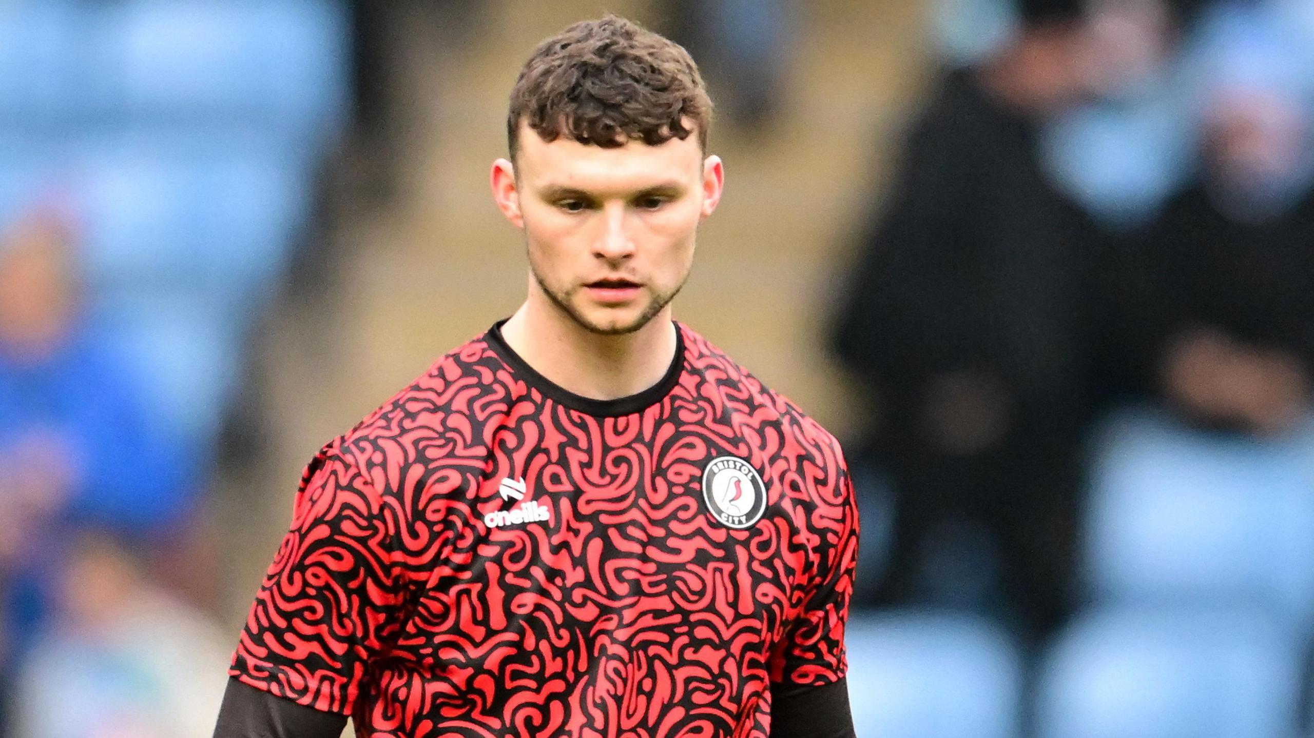 Luke McNally warming up before a game on the pitch