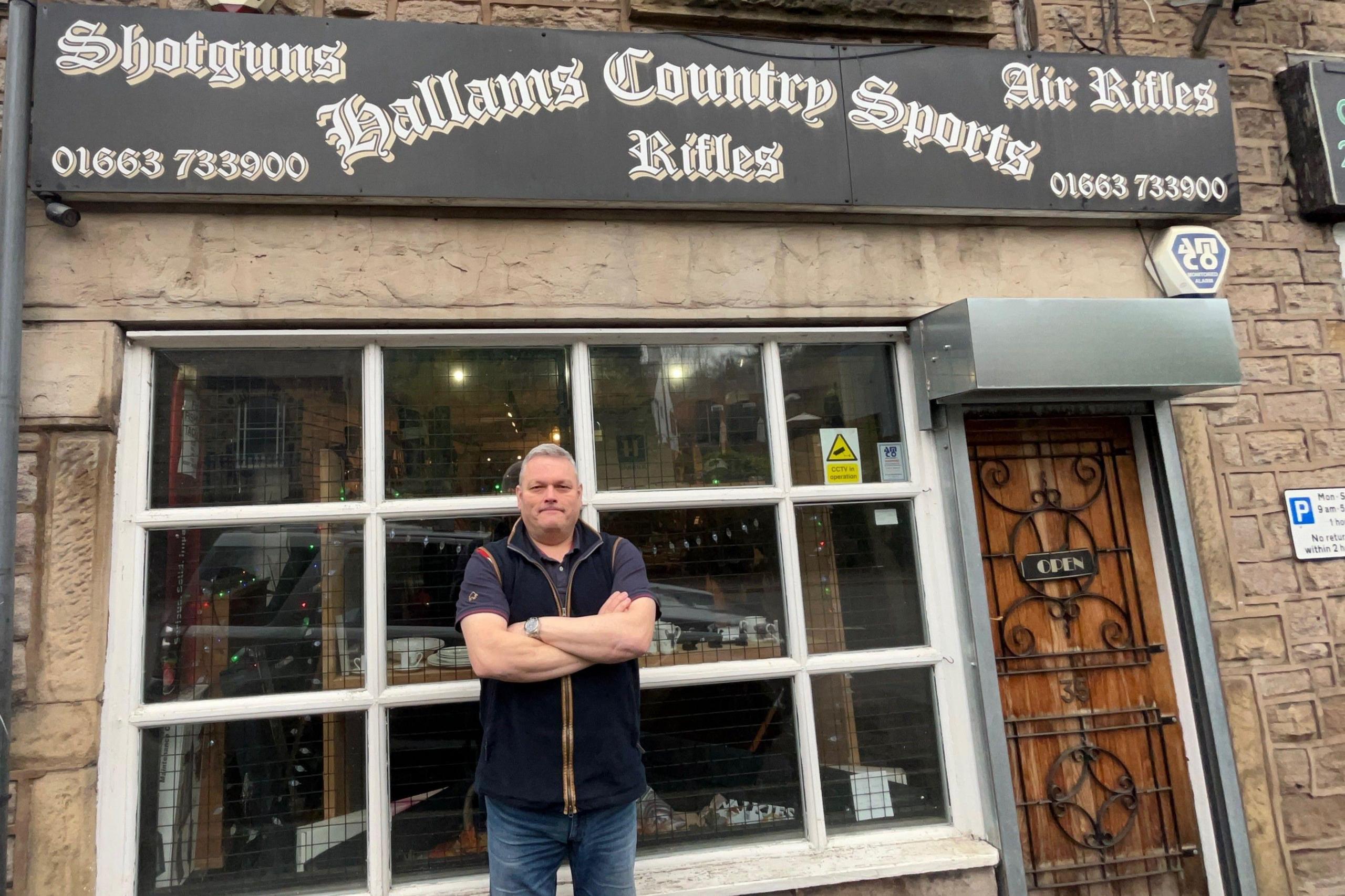 Robert Hallam, stood outside his shop, which is a typical old fashioned high street frontage 