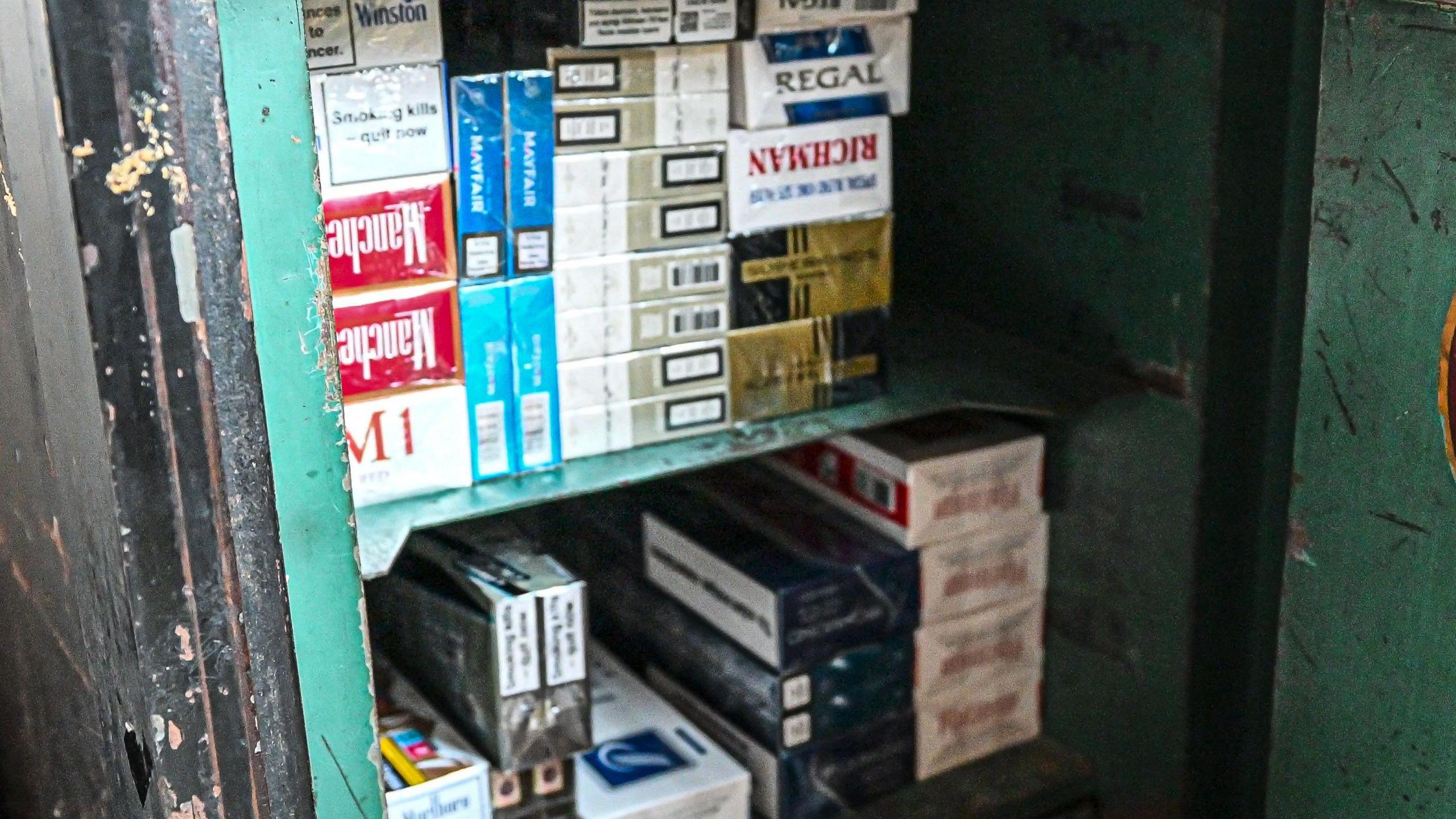 Piles of cigarette packets piled up in what appears to be a safe.