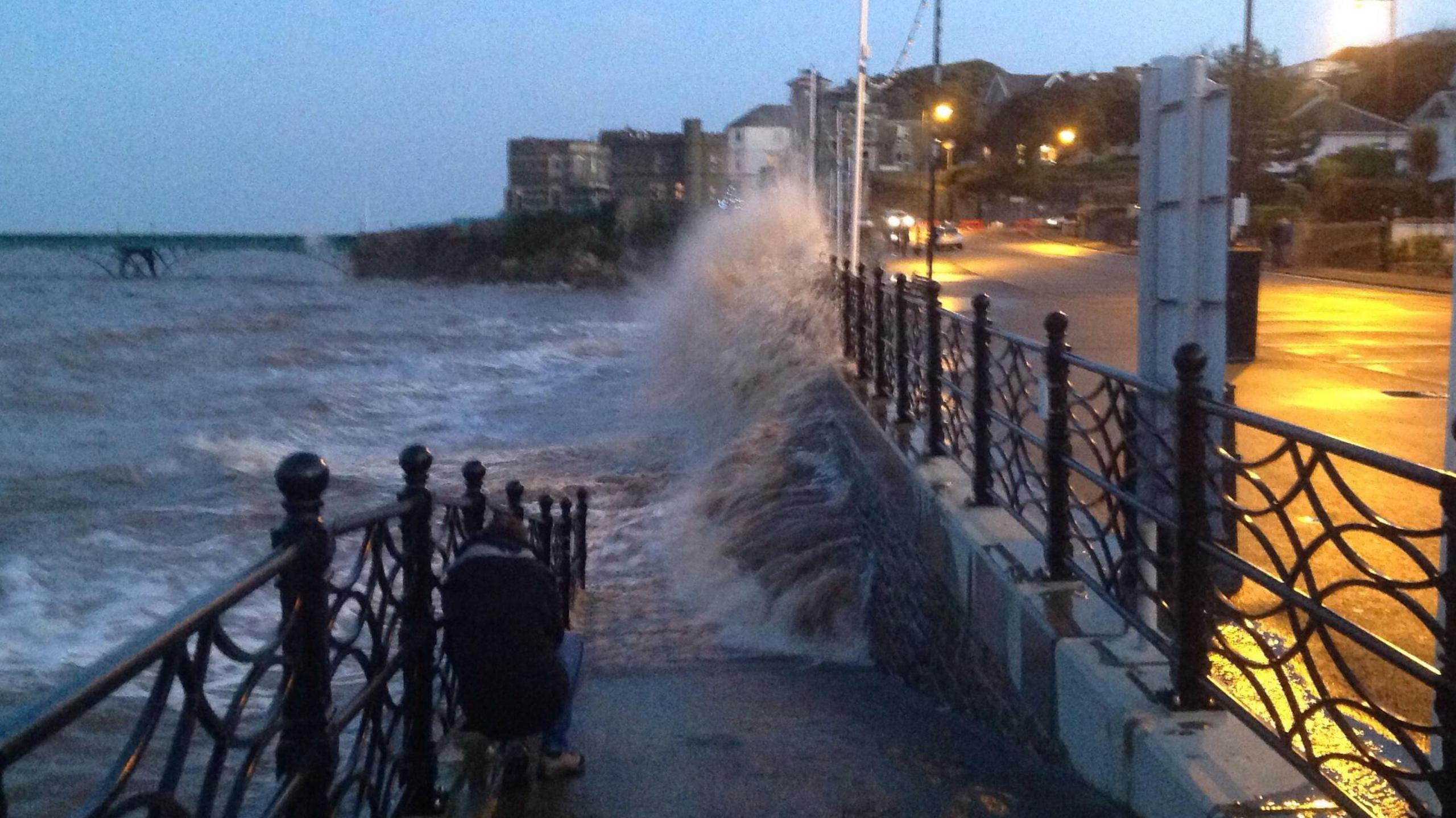 Waves crash against the sea wall in Clevedon. The town's Victorian pier can be seen in the background.