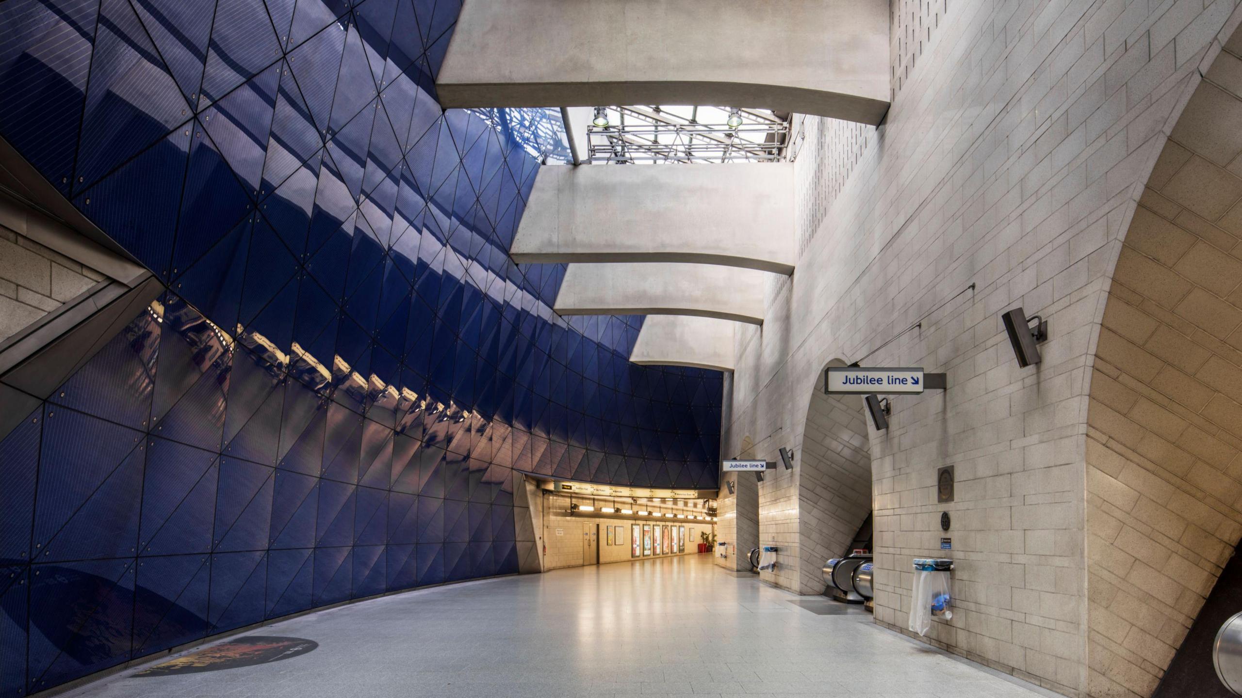 A hall in the station, with blue panelling on one side, and open windows above.